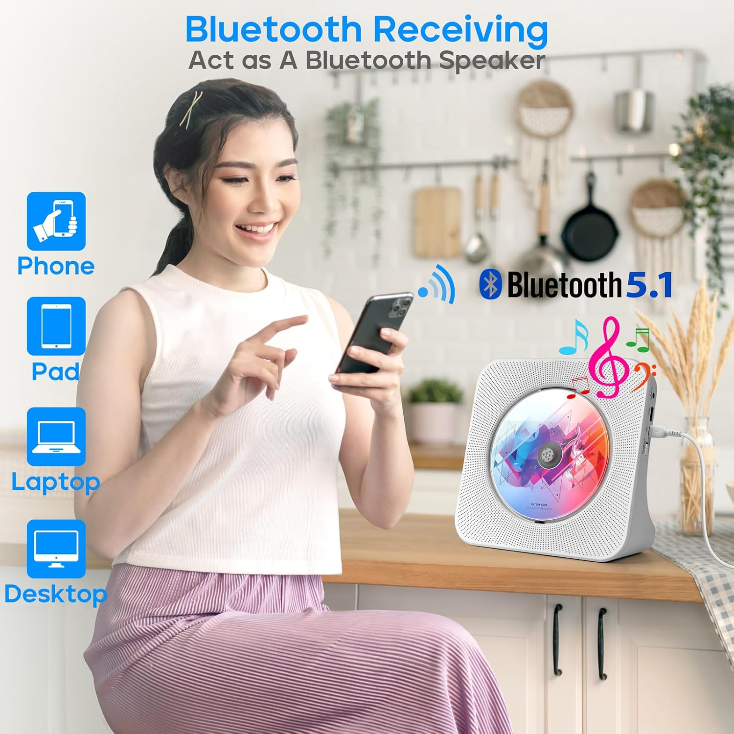 Eine Frau hält ein Smartphone neben einem Bluetooth-CD-Player in einer Küche.
