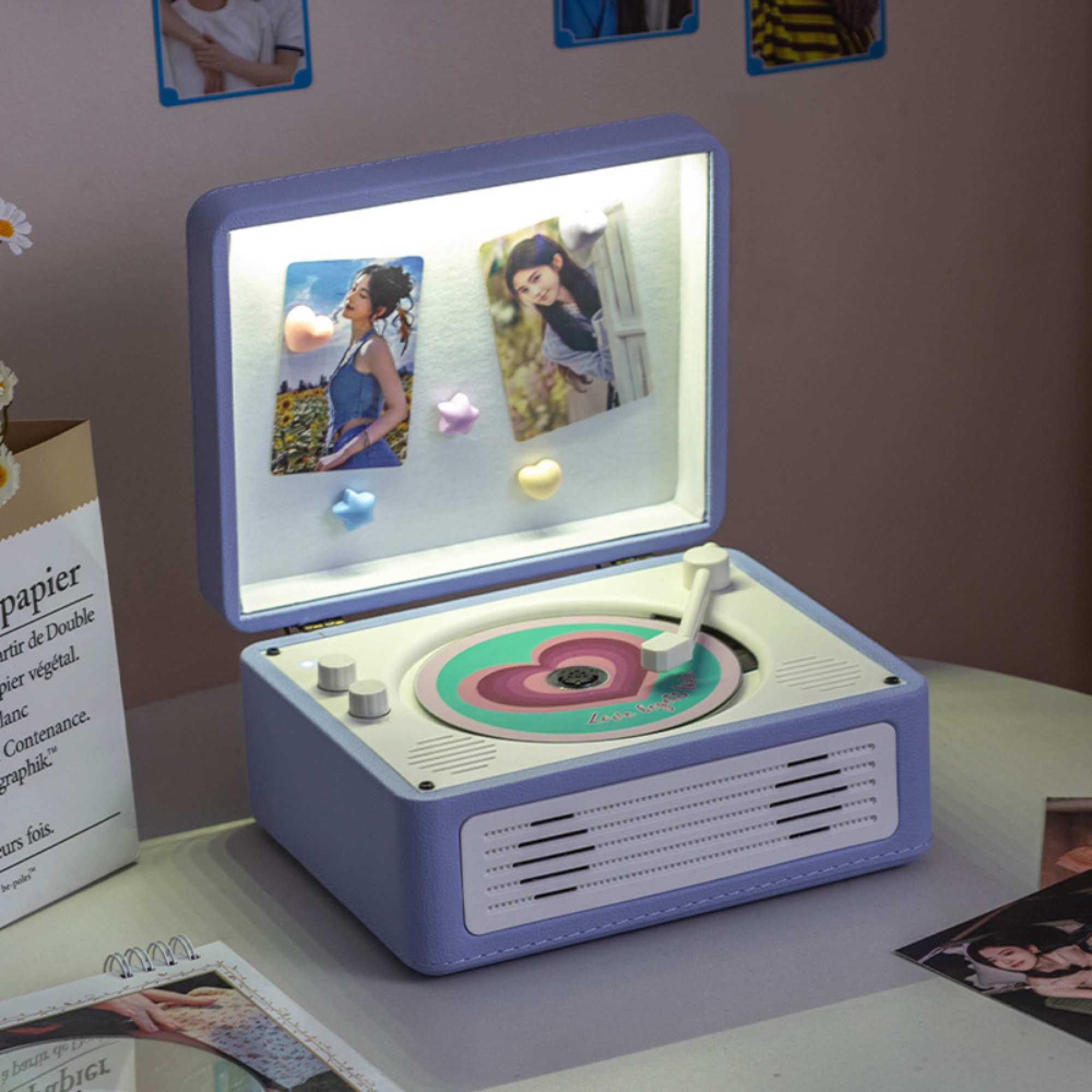 Ein beleuchteter, hellvioletter Retro-Musikplayer mit Fotos im offenen Deckel und einer Herz-Schallplatte.