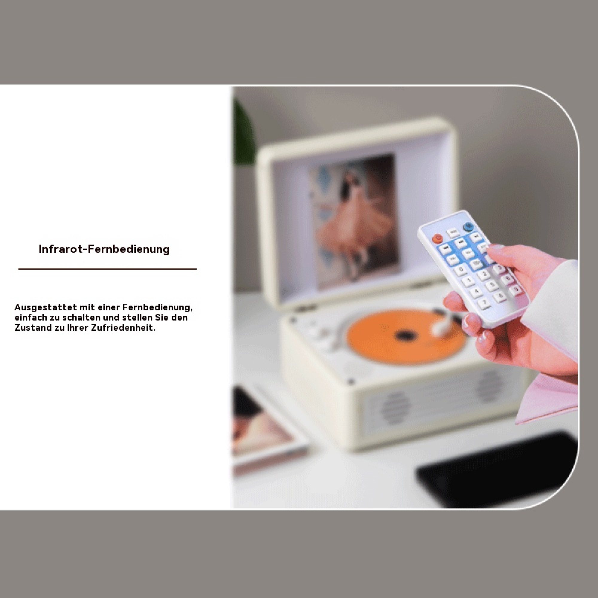 Eine Hand bedient eine weiße Fernbedienung vor einem beigen CD-Player auf einem Tisch.