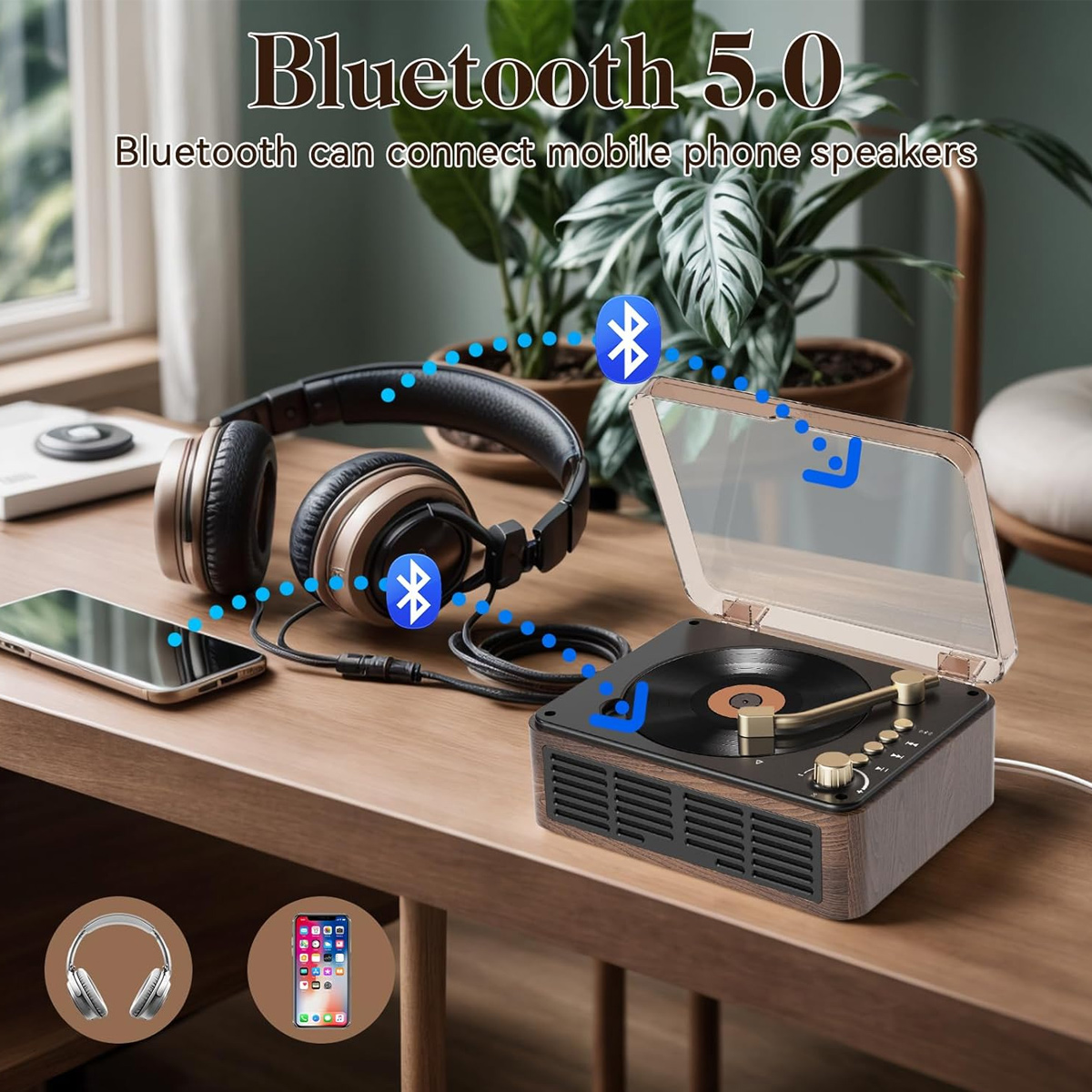 Bluetooth-Plattenspieler verbunden mit Kopfhörern und Smartphone auf einem Holztisch.
