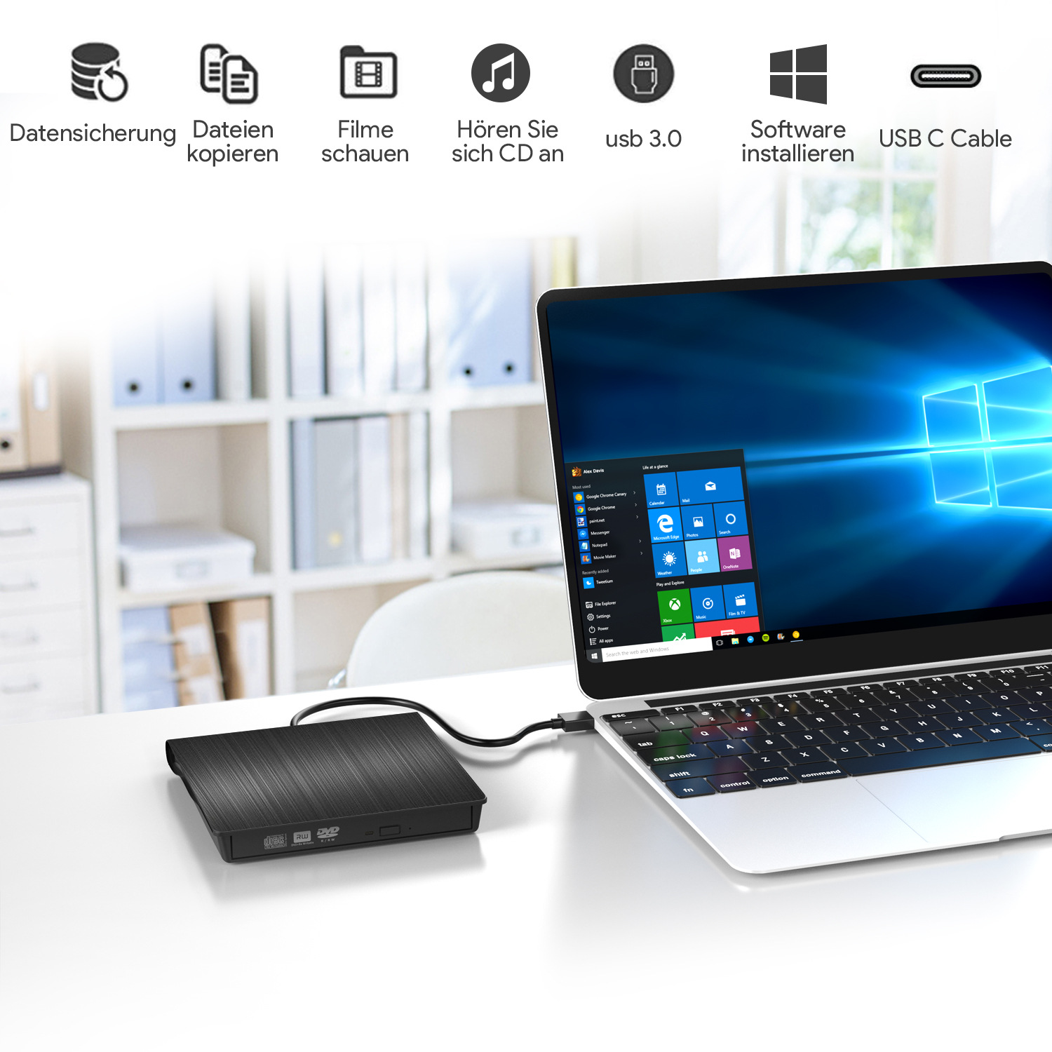 Externes schwarzes Laufwerk per USB-C Kabel an einem Laptop angeschlossen auf einem Tisch vor einem Regal.