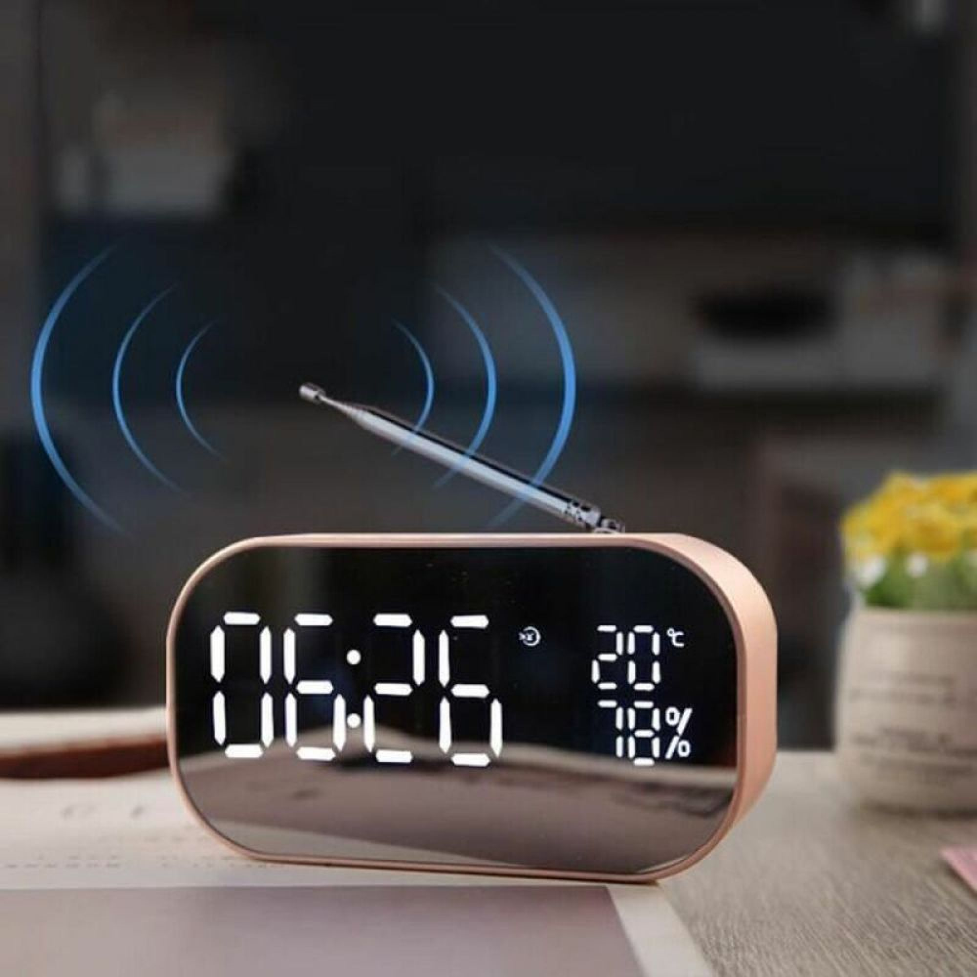 Ein rosafarbener digitaler Wecker auf einem Tisch zeigt 06:26, 20°C und 78% Luftfeuchtigkeit an.