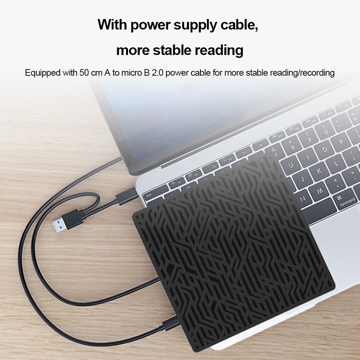 Ein schwarzes geometrisches Gerät mit Stromkabel ist neben einem Laptop auf einem Tisch platziert.