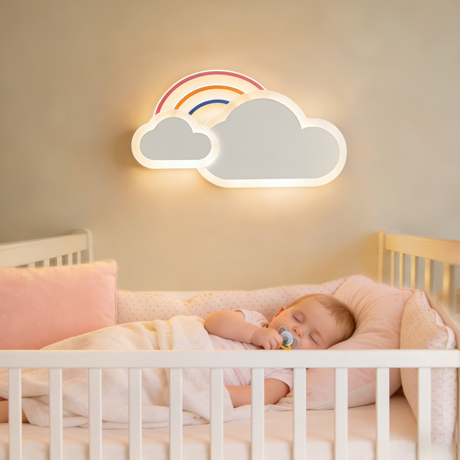 Ein Baby schläft in einem weißen Gitterbett mit Schnuller, unter einer leuchtenden Wolken-Regenbogen-Lampe.