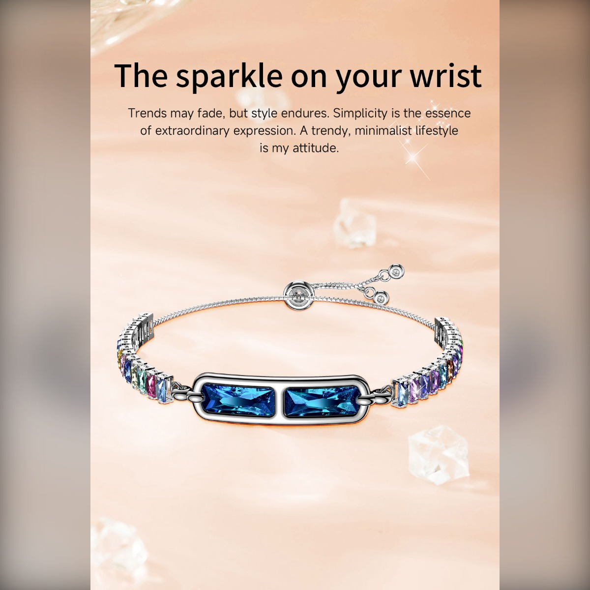 Ein silbernes Armband mit zwei blauen und vielen bunten Zirkoniasteinen vor beigem Hintergrund mit Text.