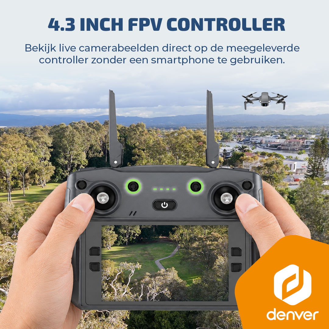 Hands holding a dark gray FPV drone controller displaying a live park view, with a drone flying in the background.