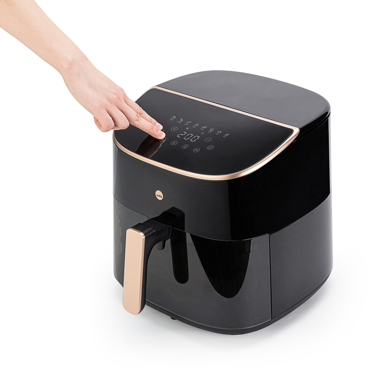Eine Hand drückt das digitale Bedienfeld einer modernen Heißluftfritteuse in Schwarz und Roségold.