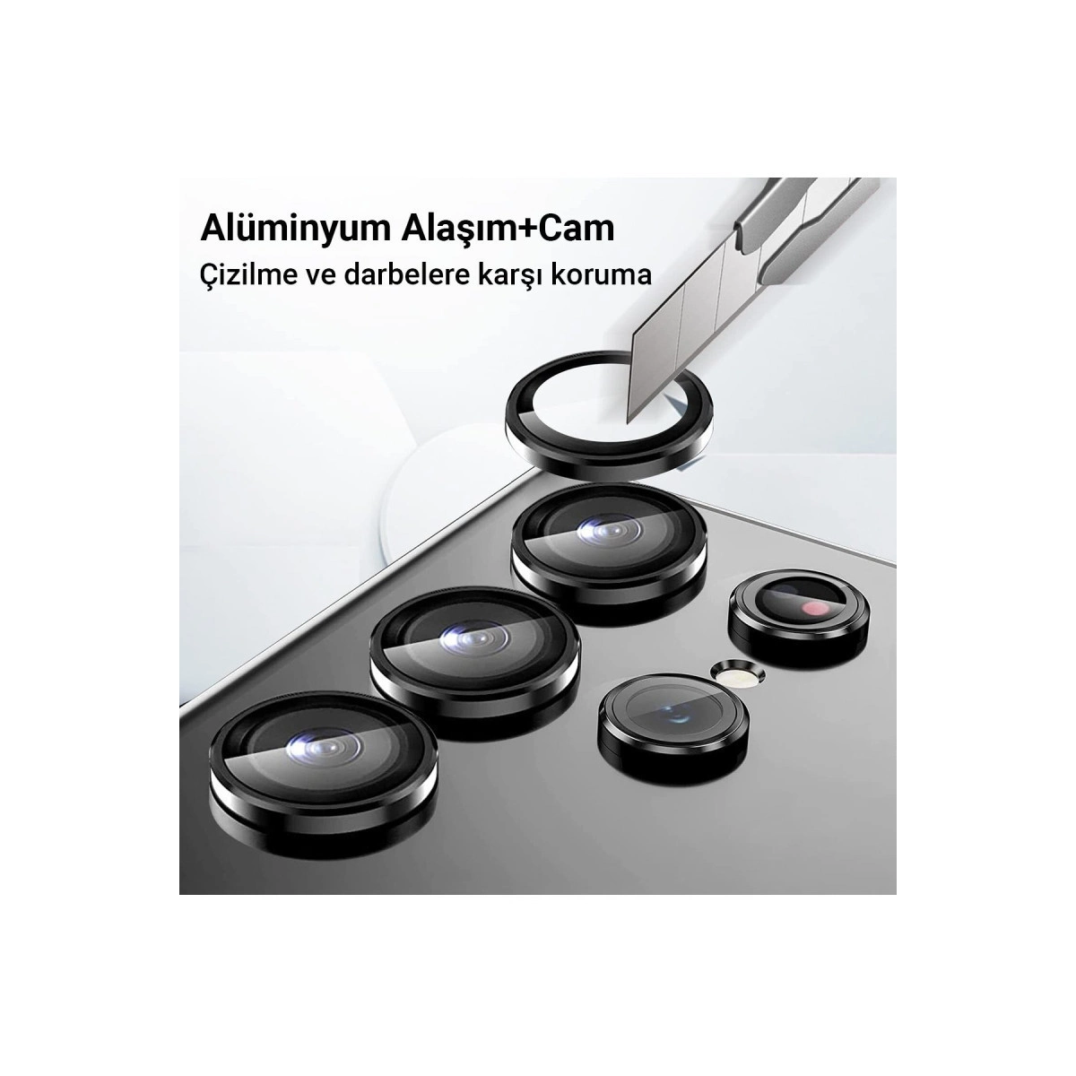 Bir akıllı telefon üzerinde alüminyum ve cam kamera lensi koruyucusunu çizen bir maket bıçağı.