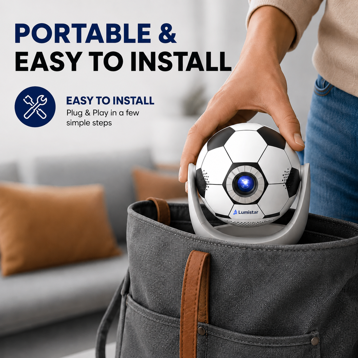 Eine Hand legt eine Fußballkamera in eine graue Tasche vor einem unscharfen Sofa.