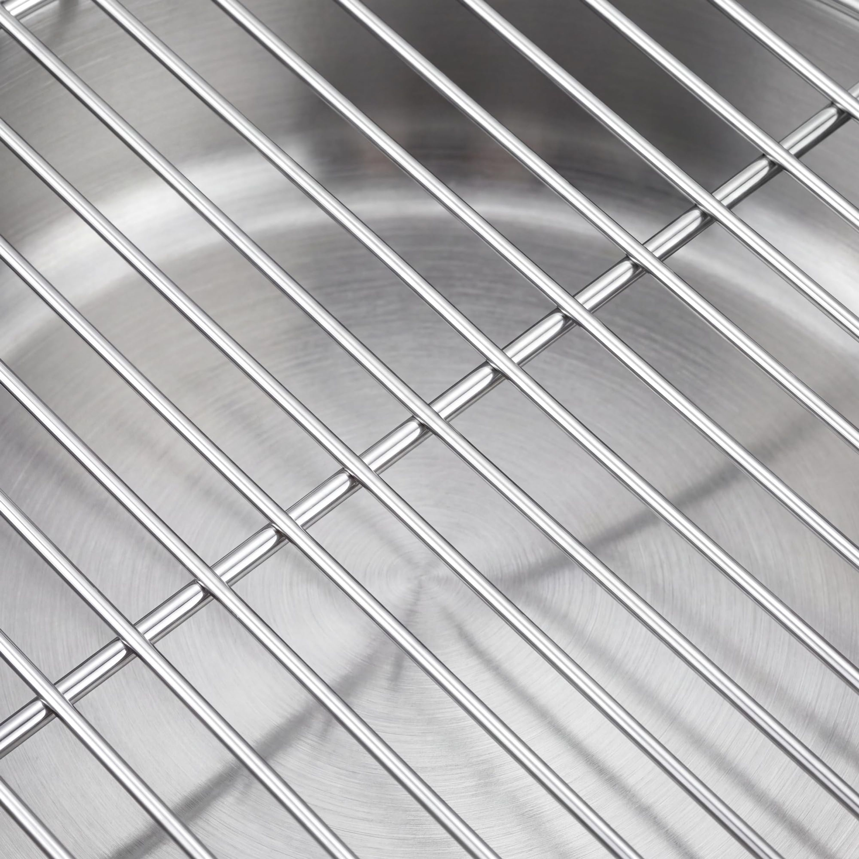 Metallgitter über der runden, gebürsteten Edelstahloberfläche eines Topfes.