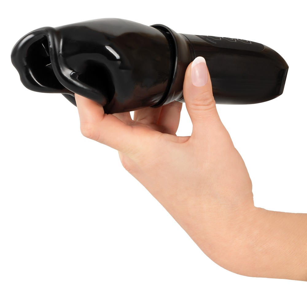 Eine Hand hält ein schwarzes, längliches Objekt mit einer wellenförmigen Öffnung gegen einen weißen Hintergrund.