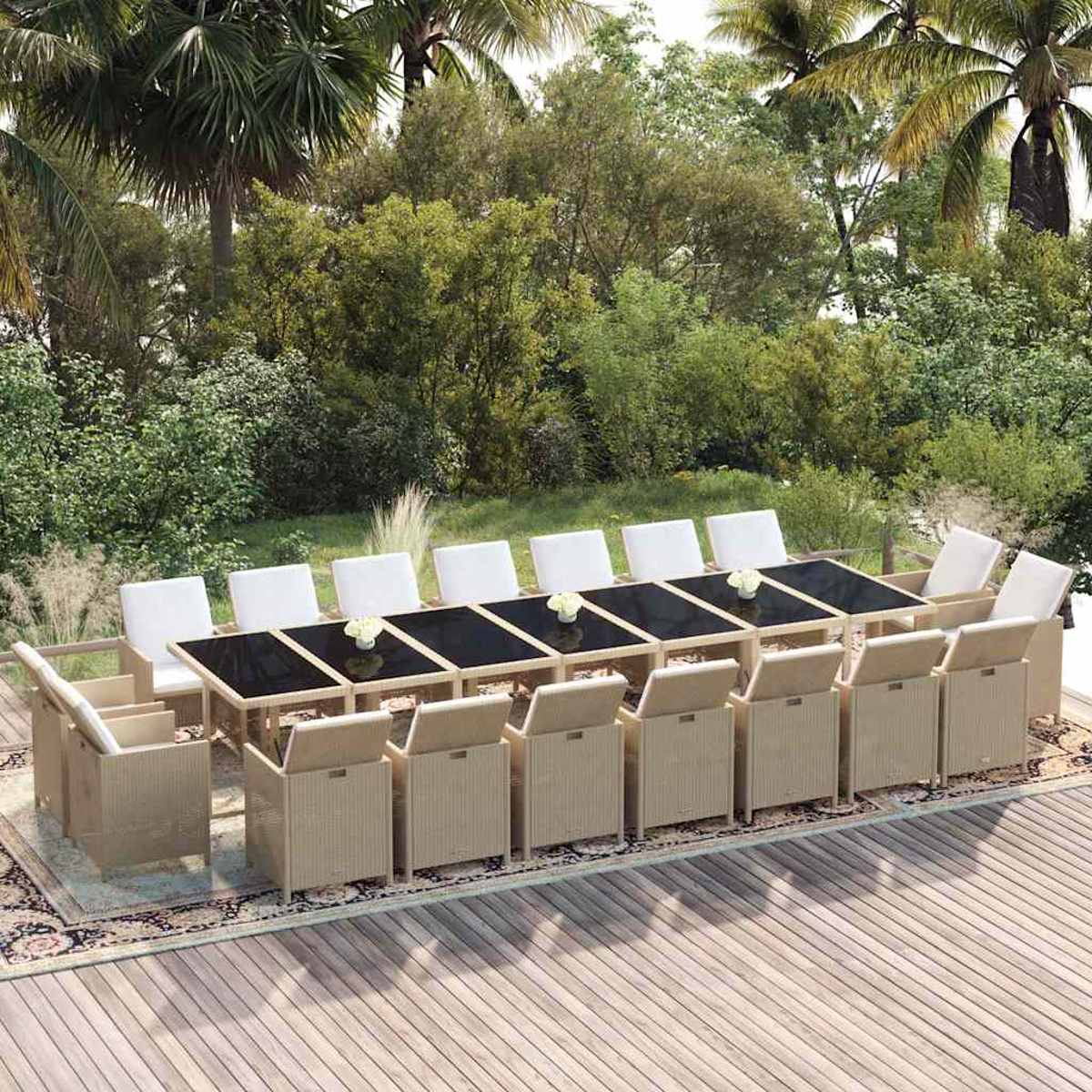 Langer Rattan-Gartentisch mit vielen Stühlen auf einer Holzterrasse vor grünen Bäumen.