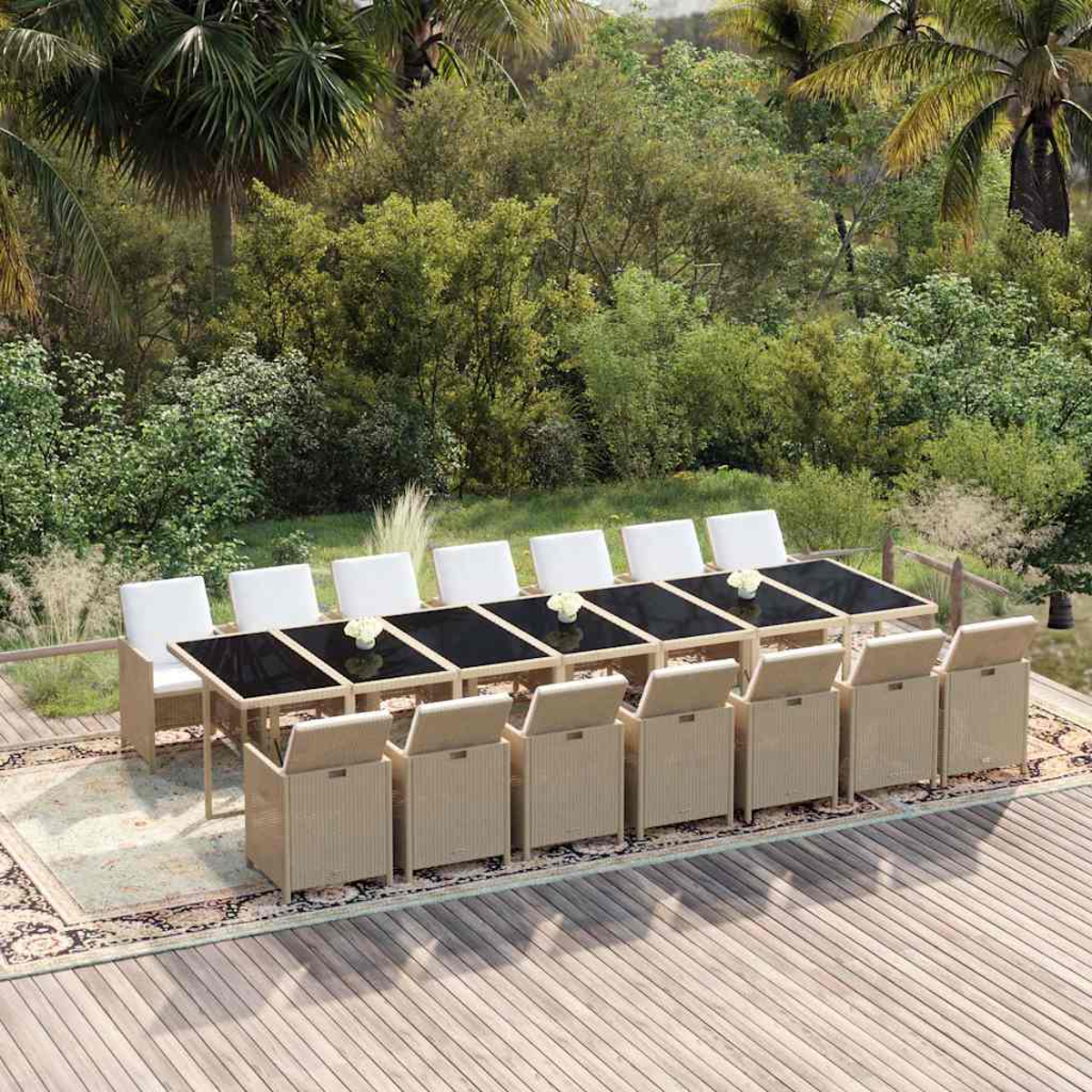 Ein langer Rattan-Gartentisch mit Stühlen und weißen Kissen steht auf einer Terrasse vor viel Grün.