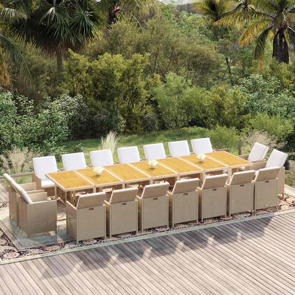 Ein großer Gartentisch mit hellen Korbstühlen und weißen Kissen auf einer Holzterrasse inmitten von viel Grün.