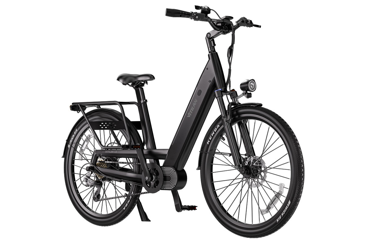 Una moderna bicicleta eléctrica negra de cuadro abierto con portaequipajes y luz delantera sobre fondo blanco.