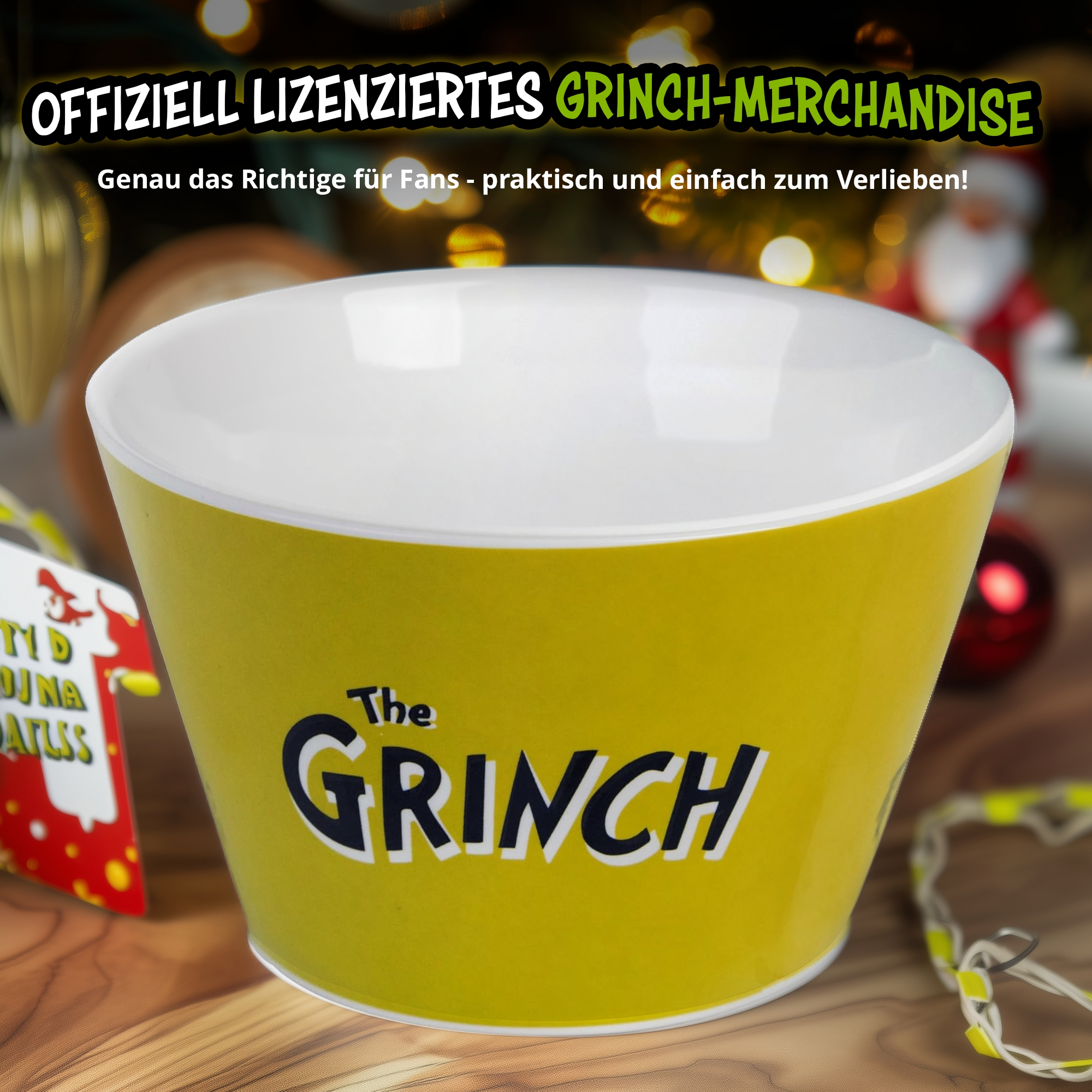 Gelbe Grinch-Schüssel mit weißem Innenraum auf einem Holztisch mit unscharfem Weihnachtshintergrund.