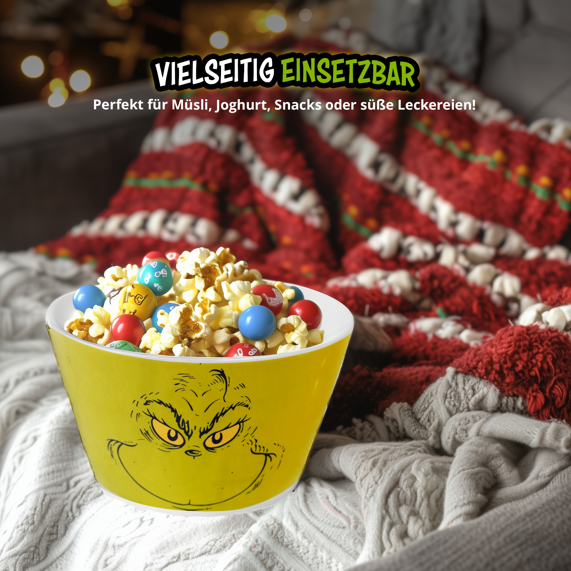 Gelbe Schale mit Grinch-Gesicht gefüllt mit Popcorn und bunten Schokolinsen vor roter Decke.