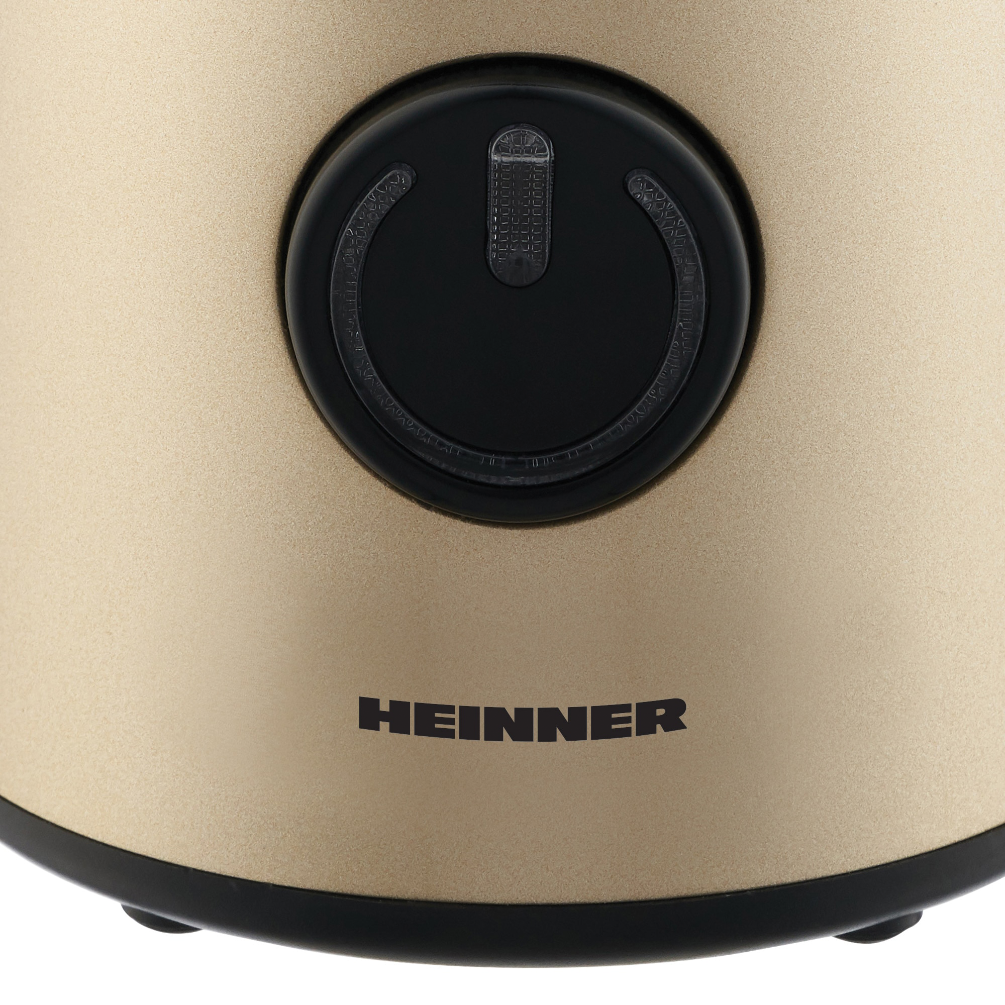 Goldfarbene Heinner-Kaffeemaschine mit einem runden schwarzen Startknopf und schwarzem Sockel.