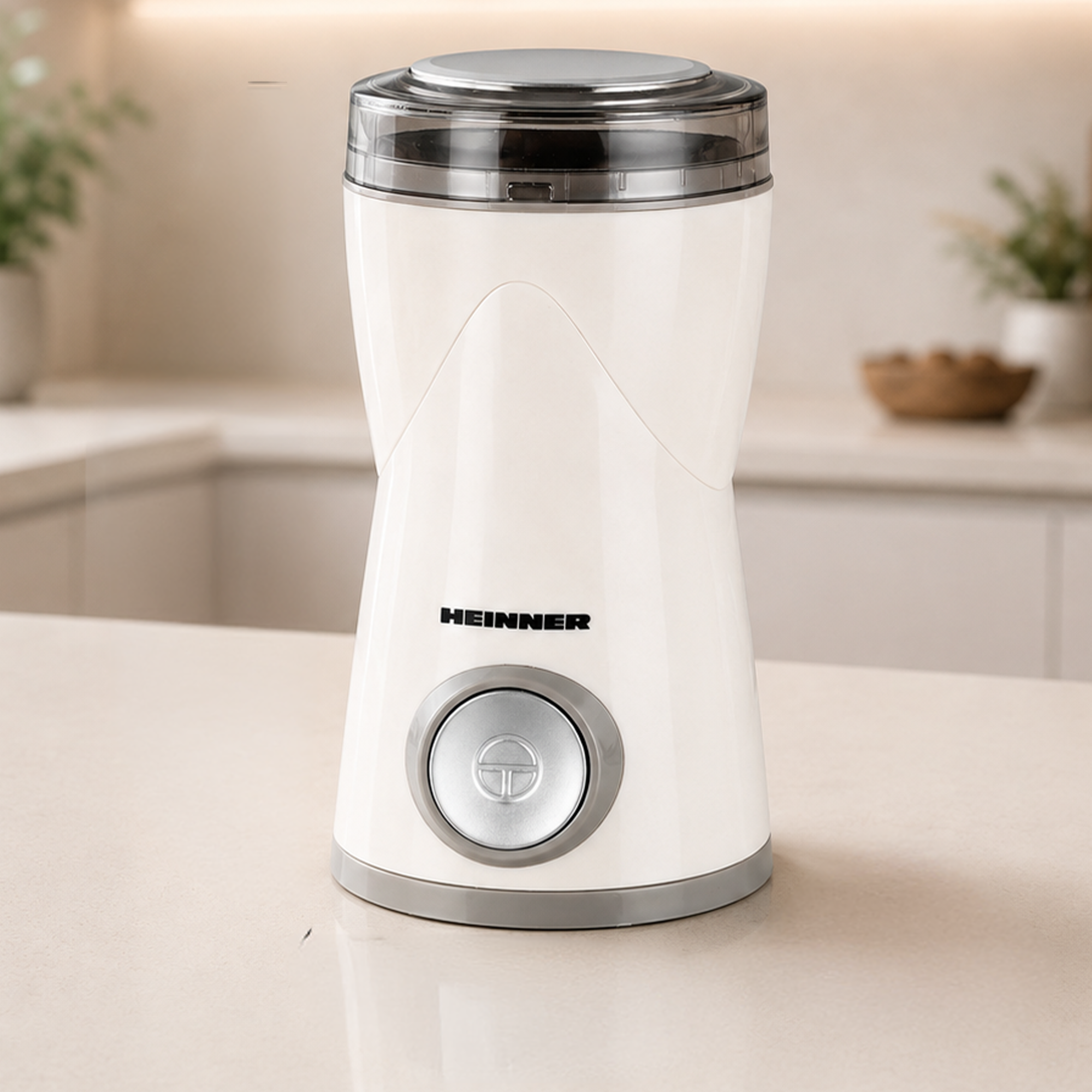 Eine weiße Heinner-Kaffeemühle mit silbernen Akzenten steht auf einer hellen Küchentheke.