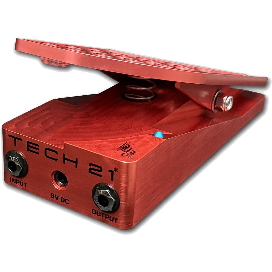 Beyaz arka planda giriş, çıkış ve 9V DC jaklarına sahip kırmızı metal Tech 21 gitar pedalı.