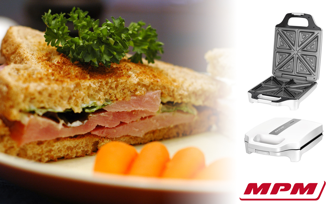 Un sándwich de jamón tostado con perejil, zanahorias baby y una sandwichera MPM a la derecha.