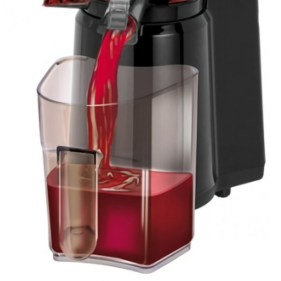 Roter Saft fließt aus einem schwarzen Entsafter in einen klaren Plastikbehälter.