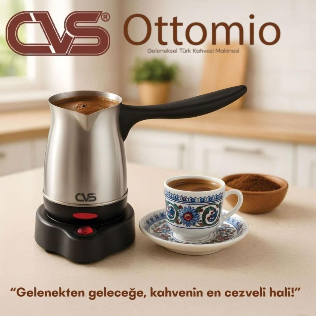 Mutfaktaki masanın üzerinde fincan ve kahve tozu olan gümüş renkli elektrikli kahve cezvesi.