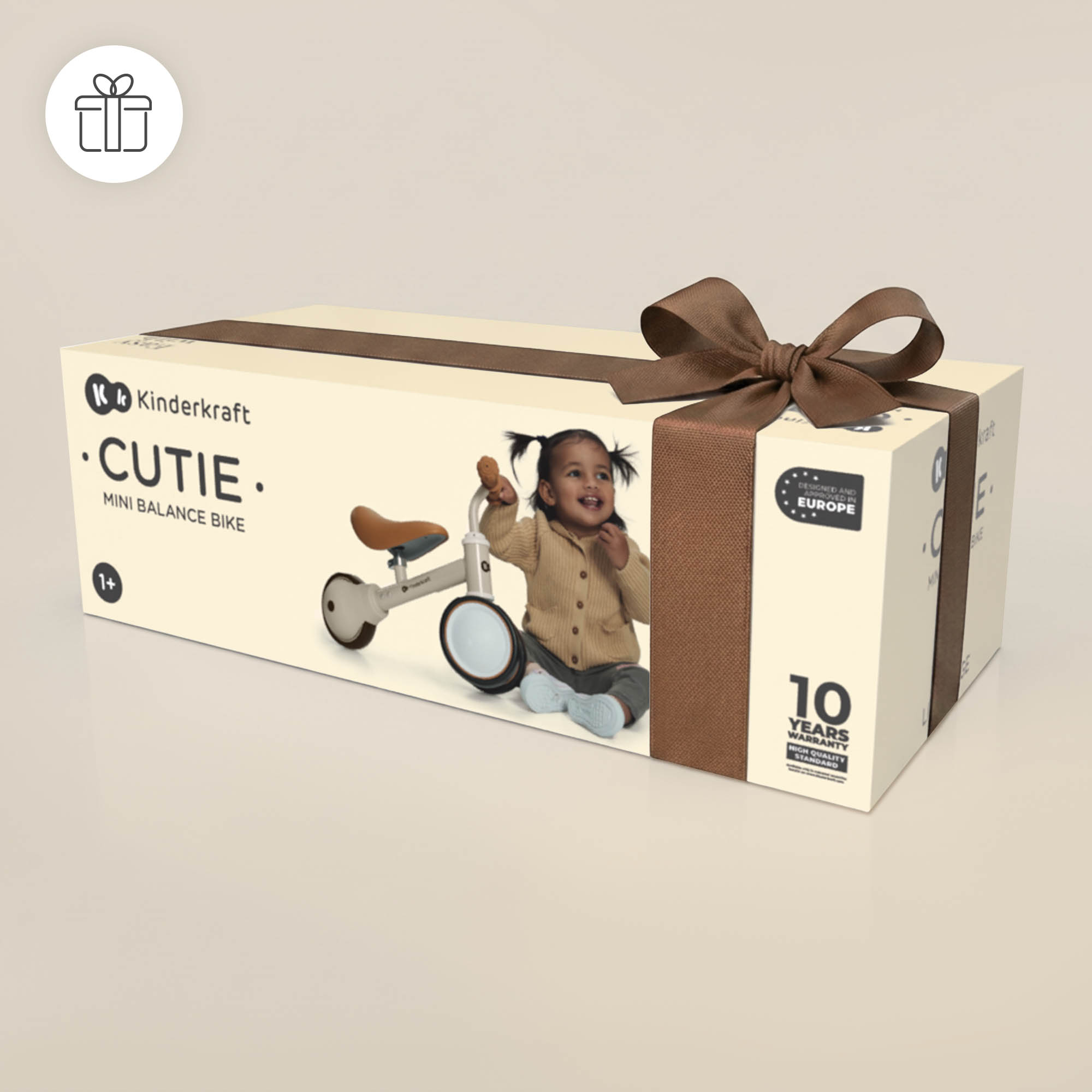 Geschenkbox für ein Kinderkraft Cutie Mini-Laufrad mit einer Schleife und einem Bild von einem Kind auf der Vorderseite.