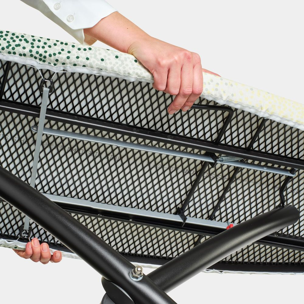 Onderkant van een bedrukte strijkplank met een zwart metalen frame.