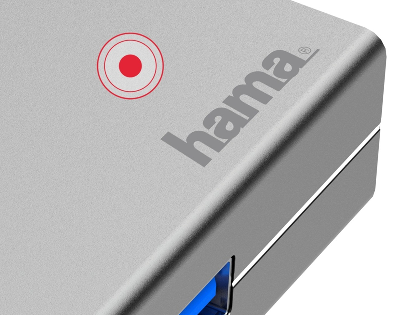 Zbliżenie srebrnej powierzchni urządzenia Hama z czerwonym symbolem koła i niebieskim portem USB.