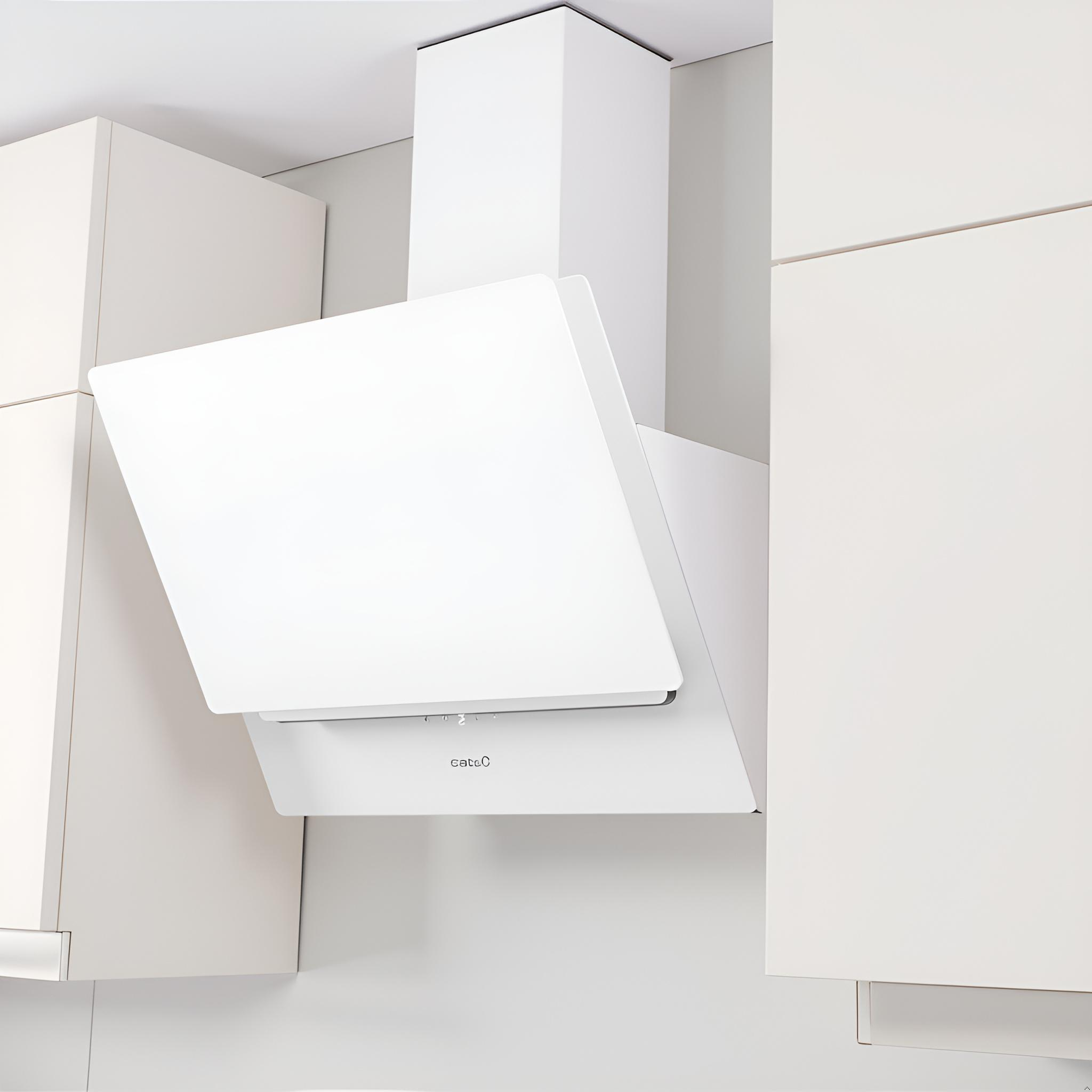 Una moderna campana extractora blanca inclinada está montada entre armarios de cocina de color beige claro.
