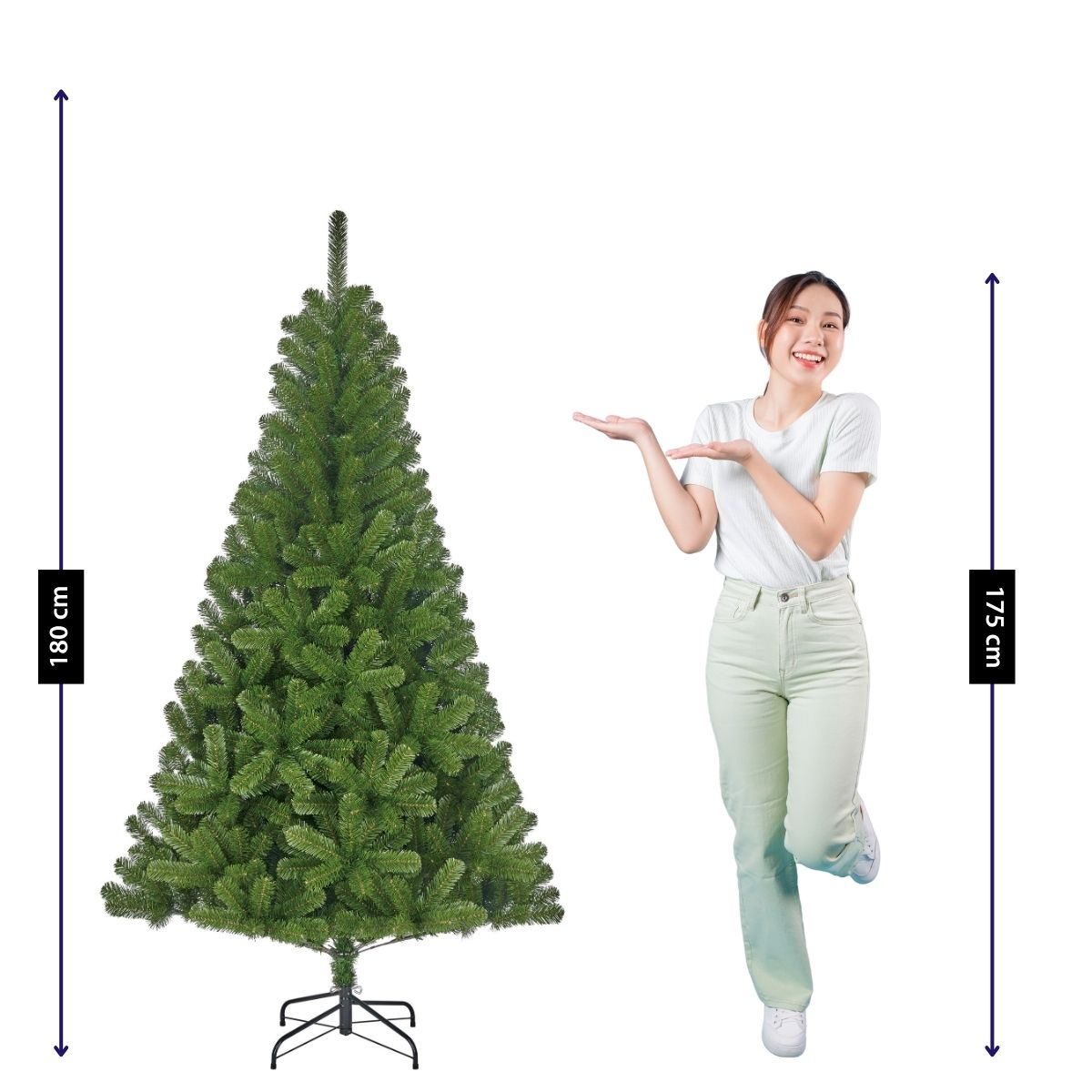 A woman points to an artificial 180 cm Christmas tree standing next to her.