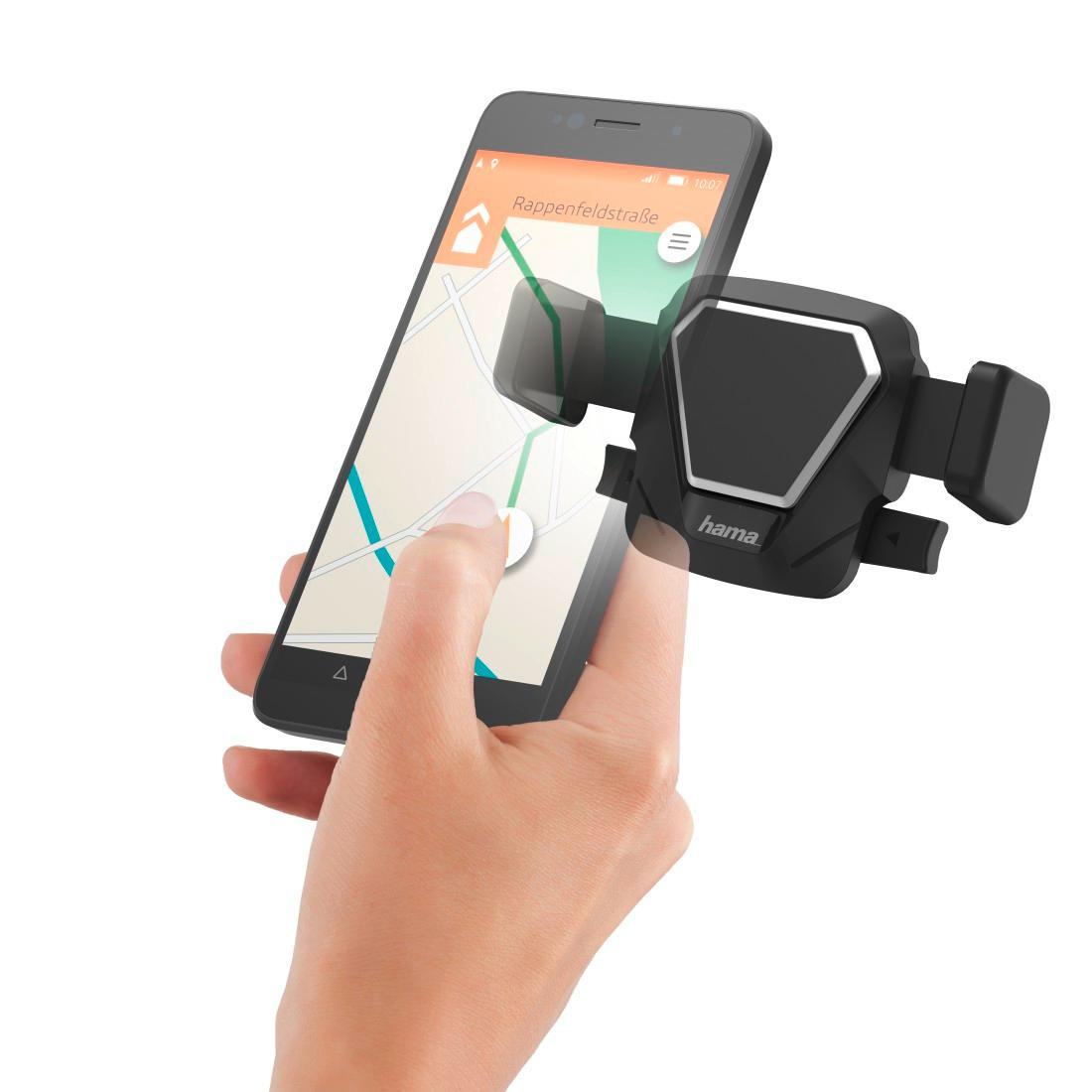 Ręka trzyma smartfon z nawigacją obok czarnego uchwytu Hama.