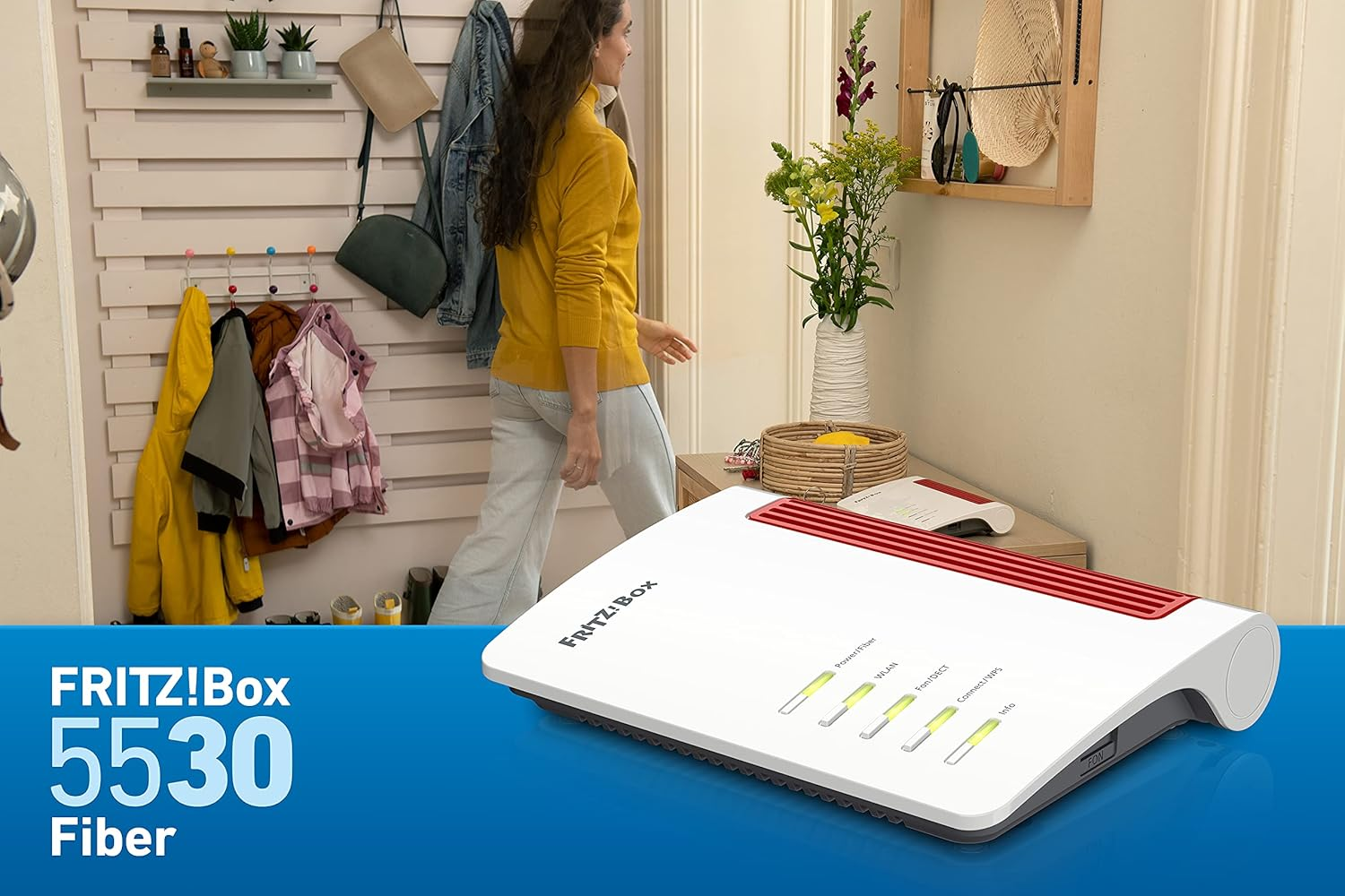 Biało-czerwony router FRITZ!Box 5530 Fiber stoi na drewnianym stoliku w jasnym przedpokoju.