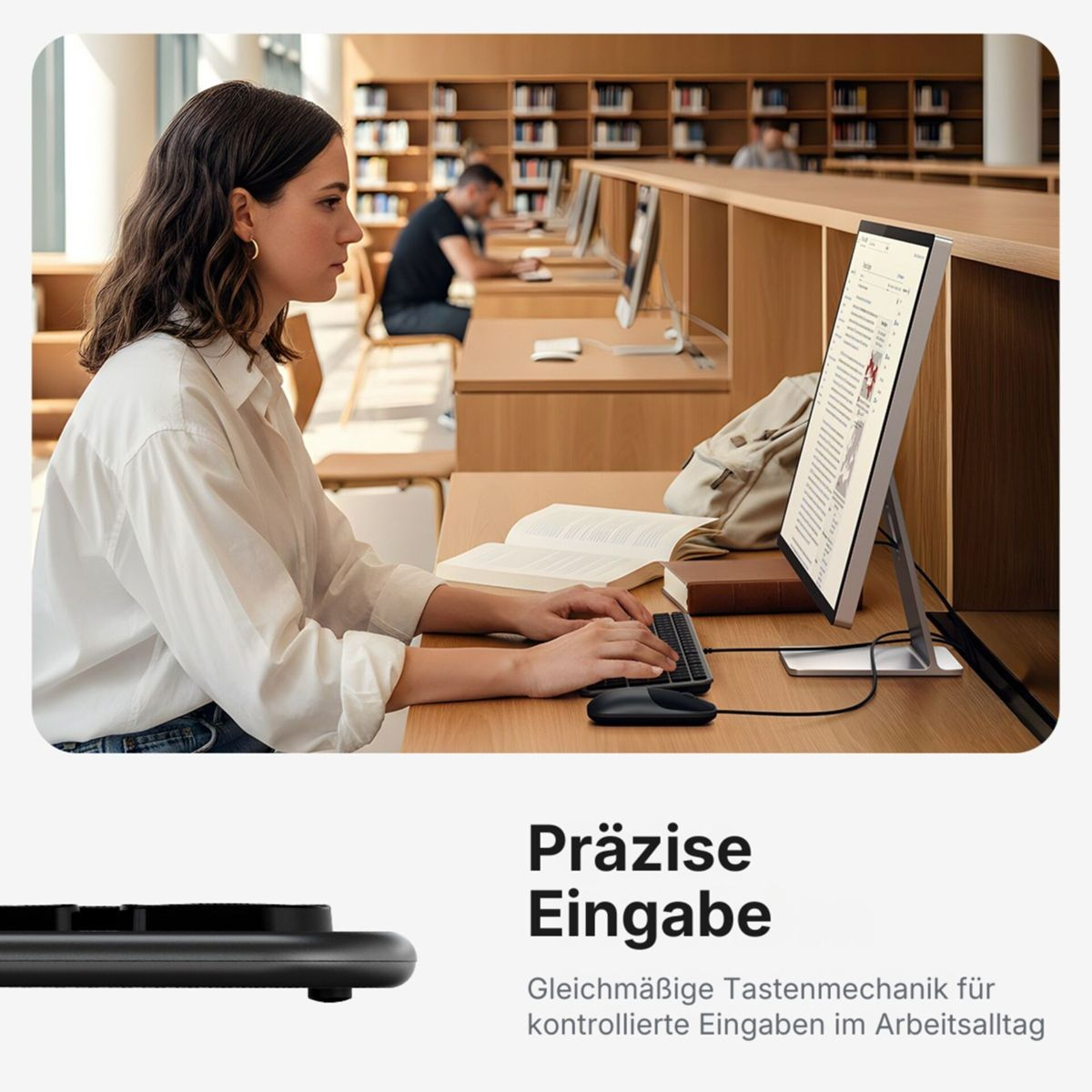 Eine Frau arbeitet in einer Bibliothek an einem Computer und tippt auf einer Tastatur.