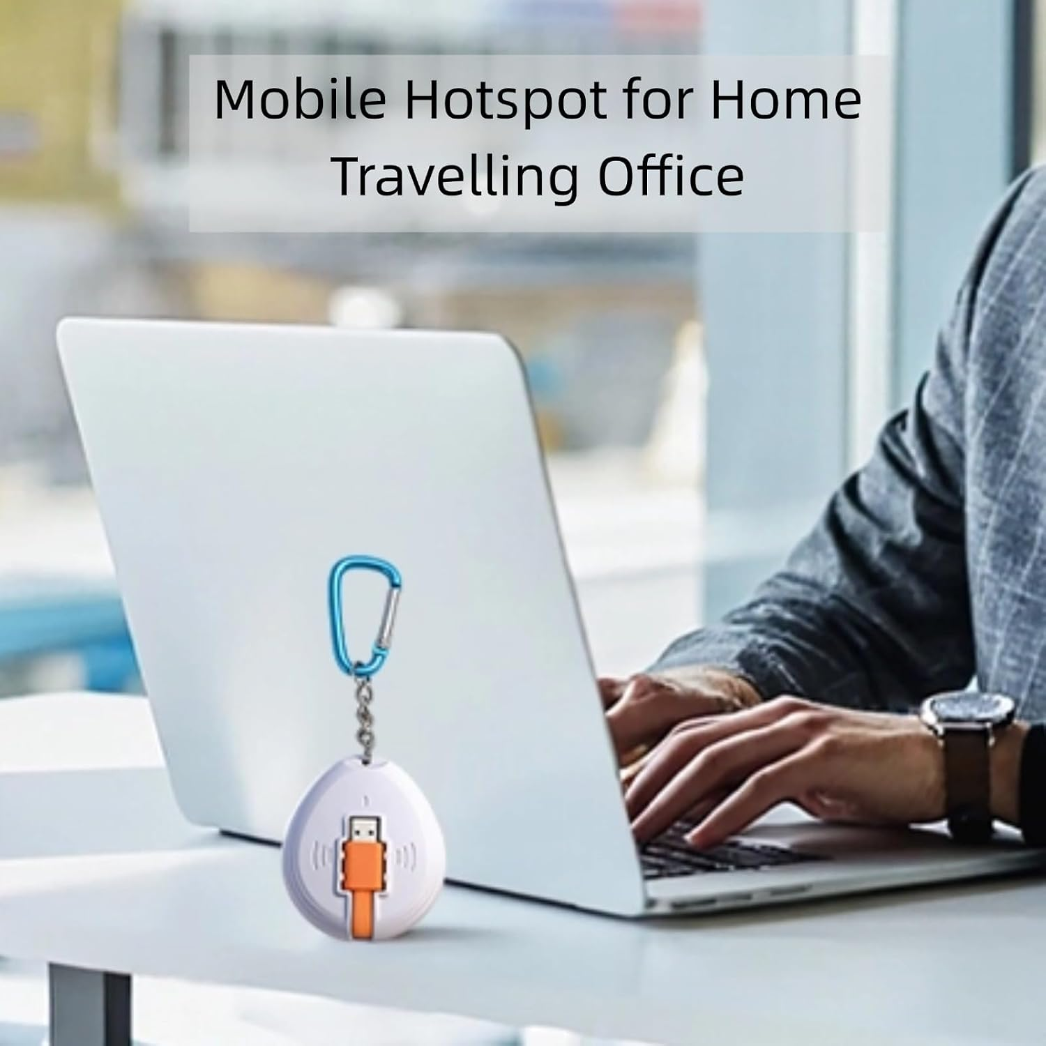 Ein weißer mobiler Hotspot mit blauem Karabiner liegt auf einem Schreibtisch neben einem Laptop.