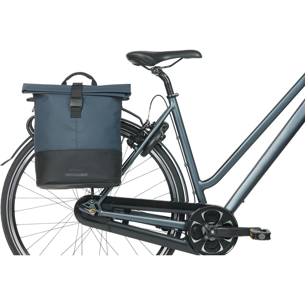 Ein blau-schwarzer Fahrradrucksack ist auf dem Gepäckträger eines dunkelgrauen Fahrrads befestigt.