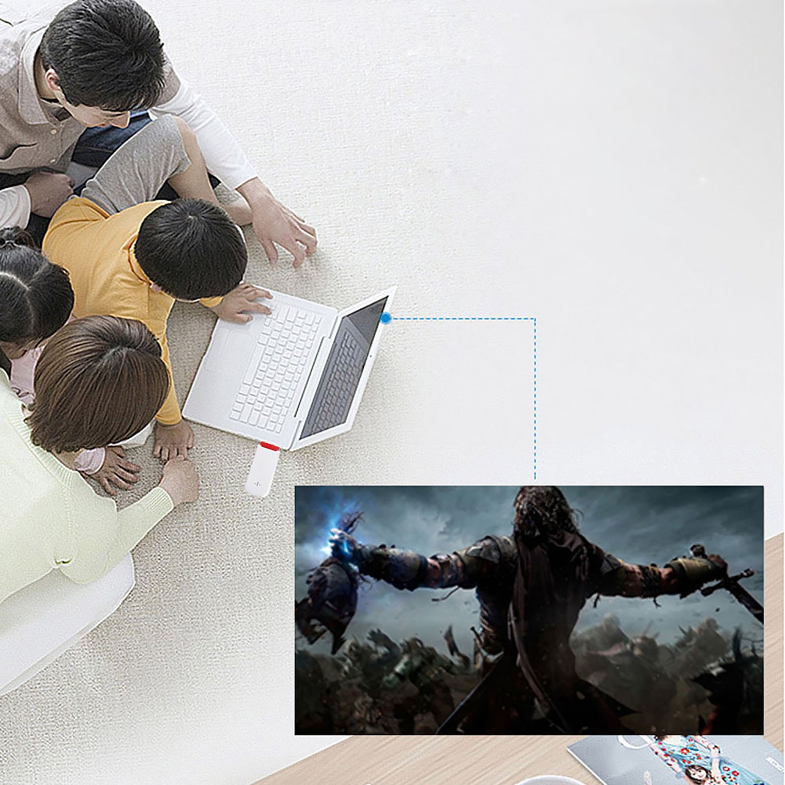 Eine Familie sitzt auf einem weißen Teppich und nutzt einen Laptop, der eine Fantasieschlacht projiziert.