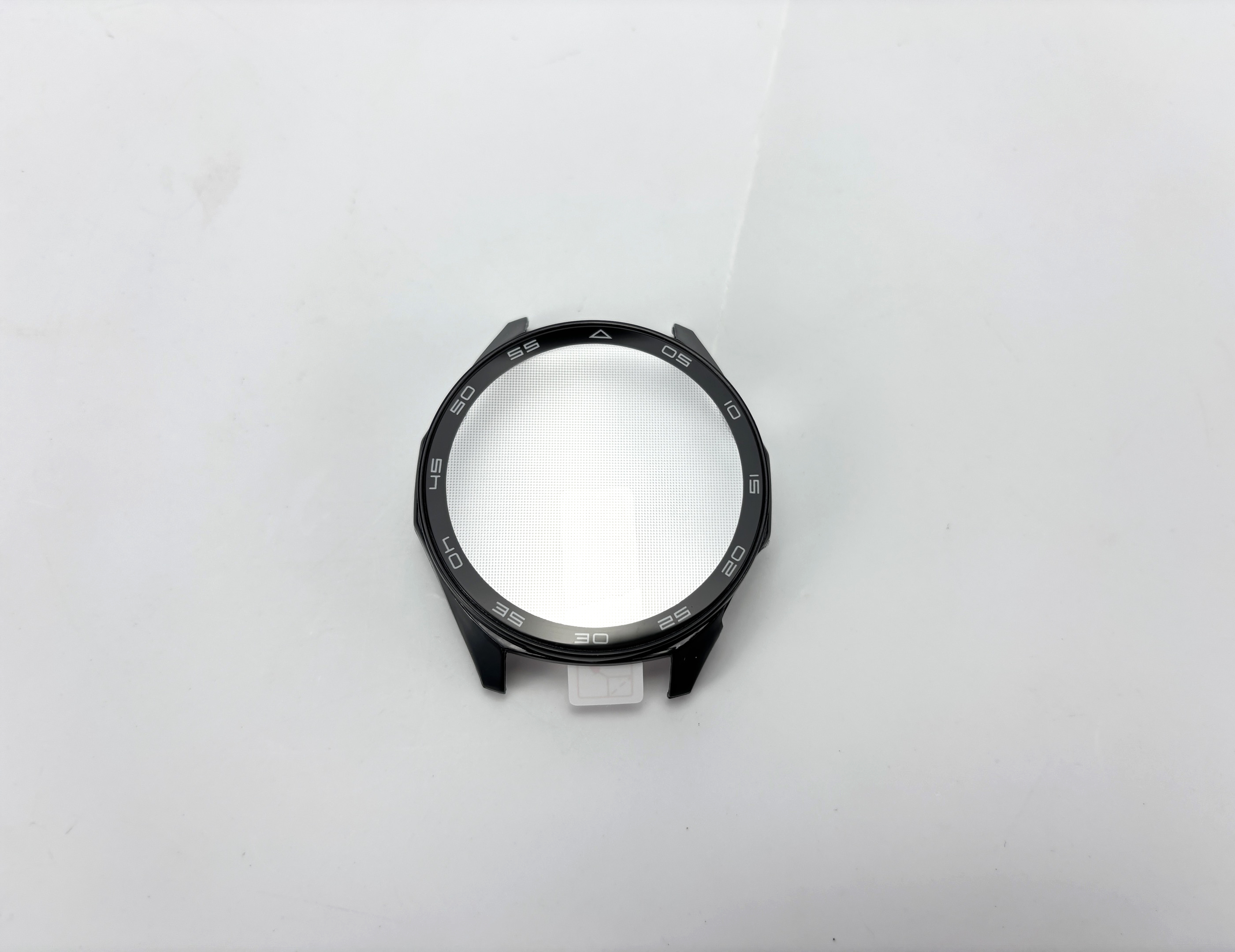 Ein schwarzes Smartwatch-Gehäuse mit einer strukturierten, silbernen Zifferblatt-Schutzfolie auf weißem Hintergrund.