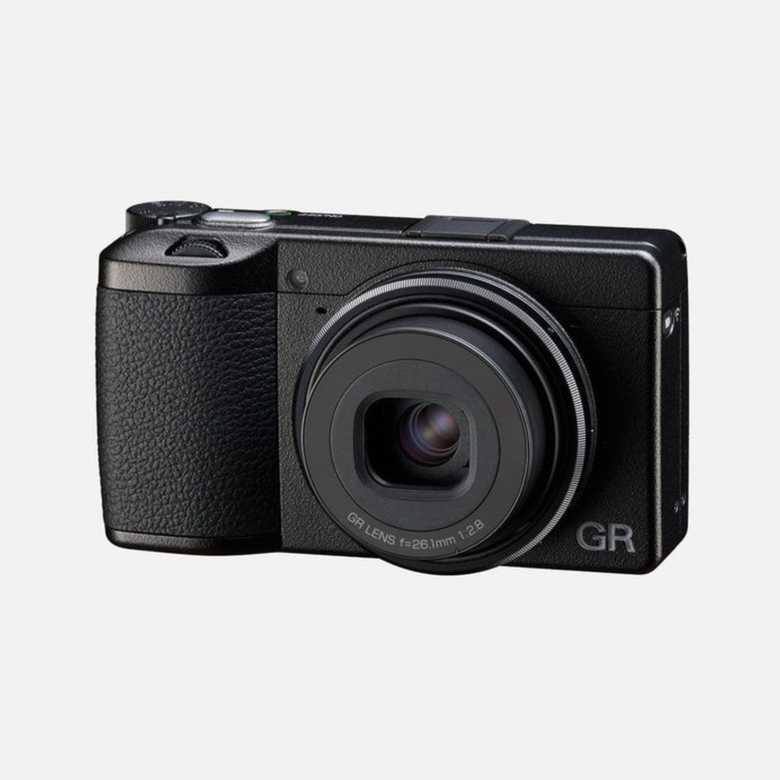 Una fotocamera compatta Ricoh GR nera con impugnatura testurizzata e obiettivo prominente su sfondo grigio.