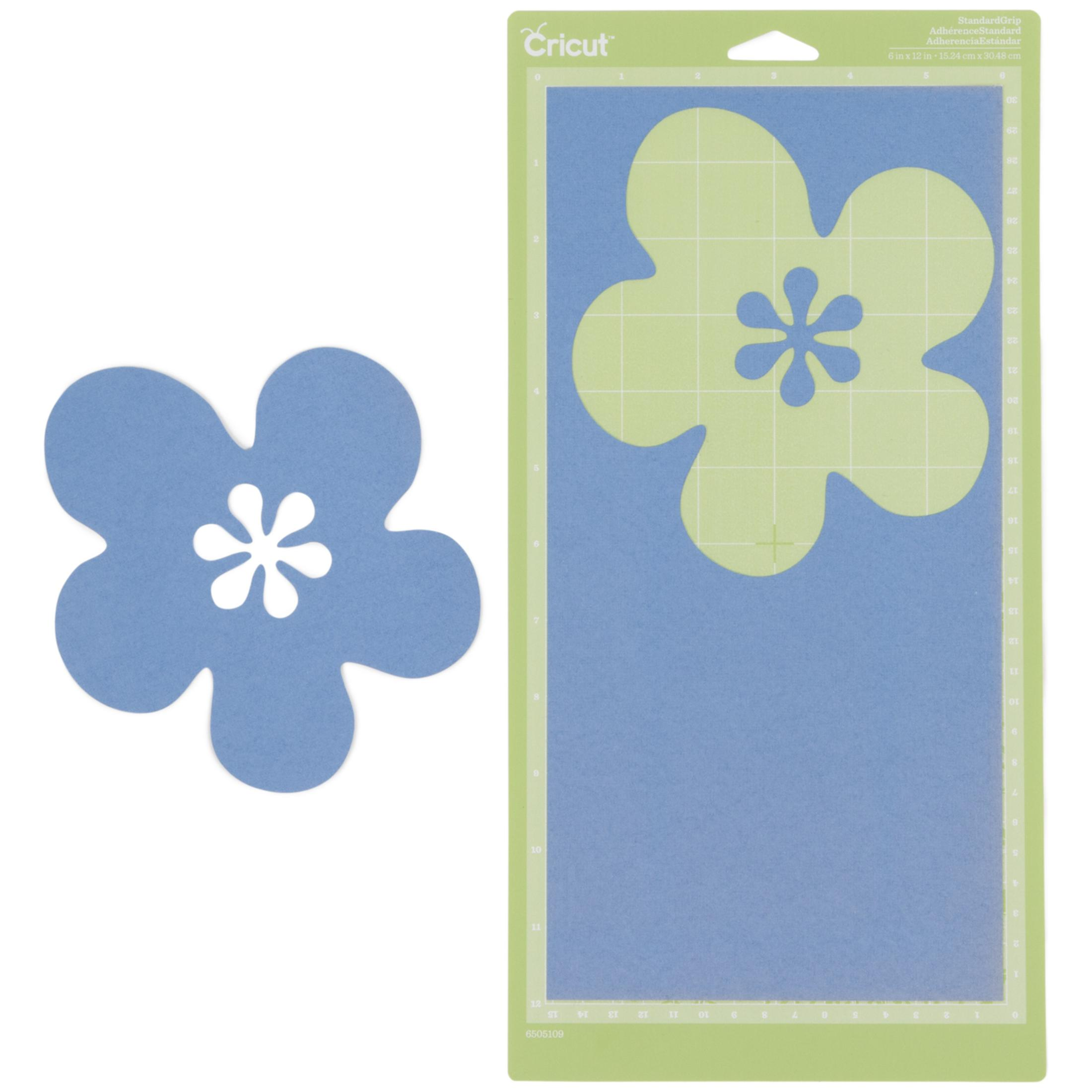 Eine grüne Cricut-Schneidematte mit blauem Papier und einem hellgrünen Blumenausschnitt sowie einer separaten blauen Blume.