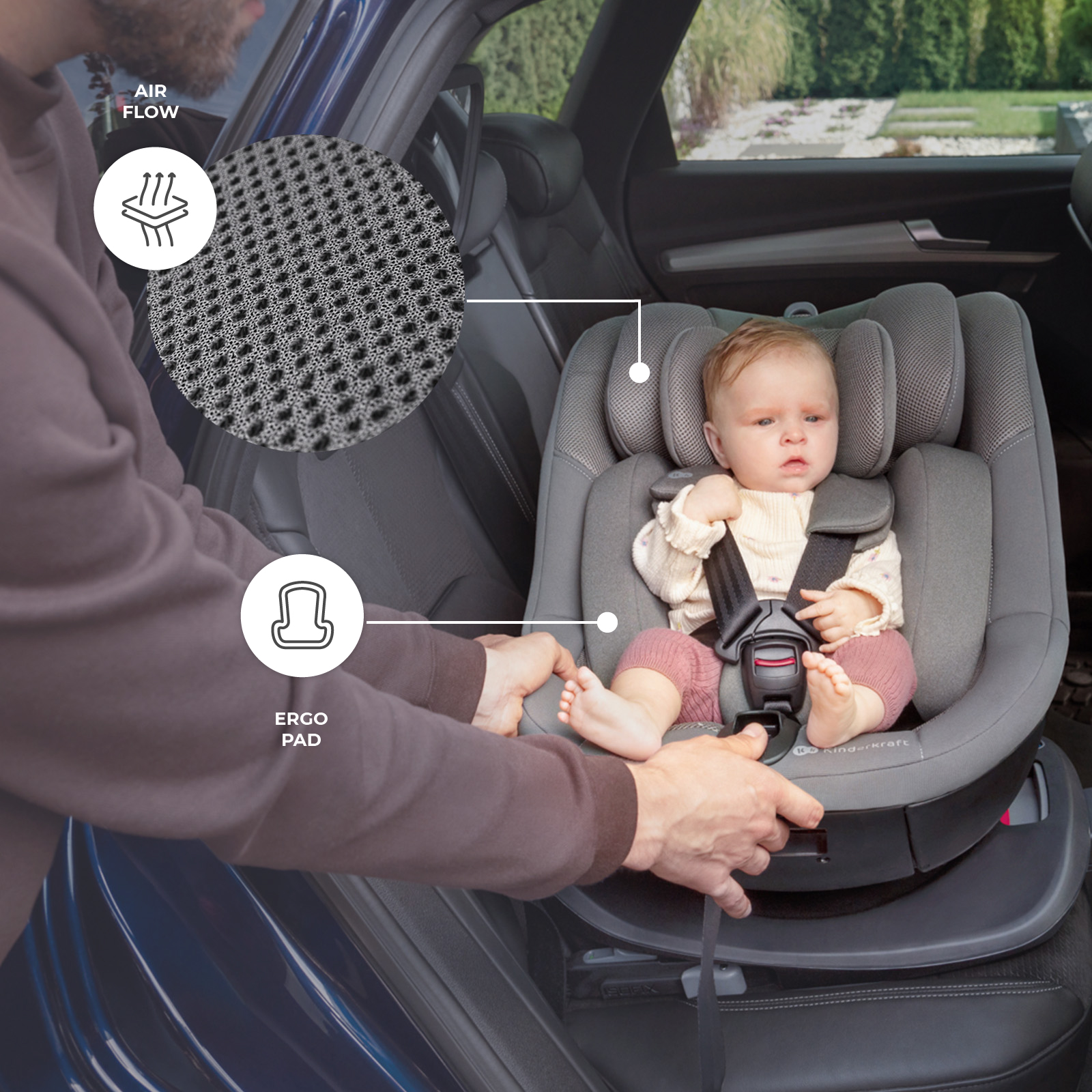Ein Baby sitzt angeschnallt in einem grauen Kindersitz im Auto, während eine Person ihn anpasst.