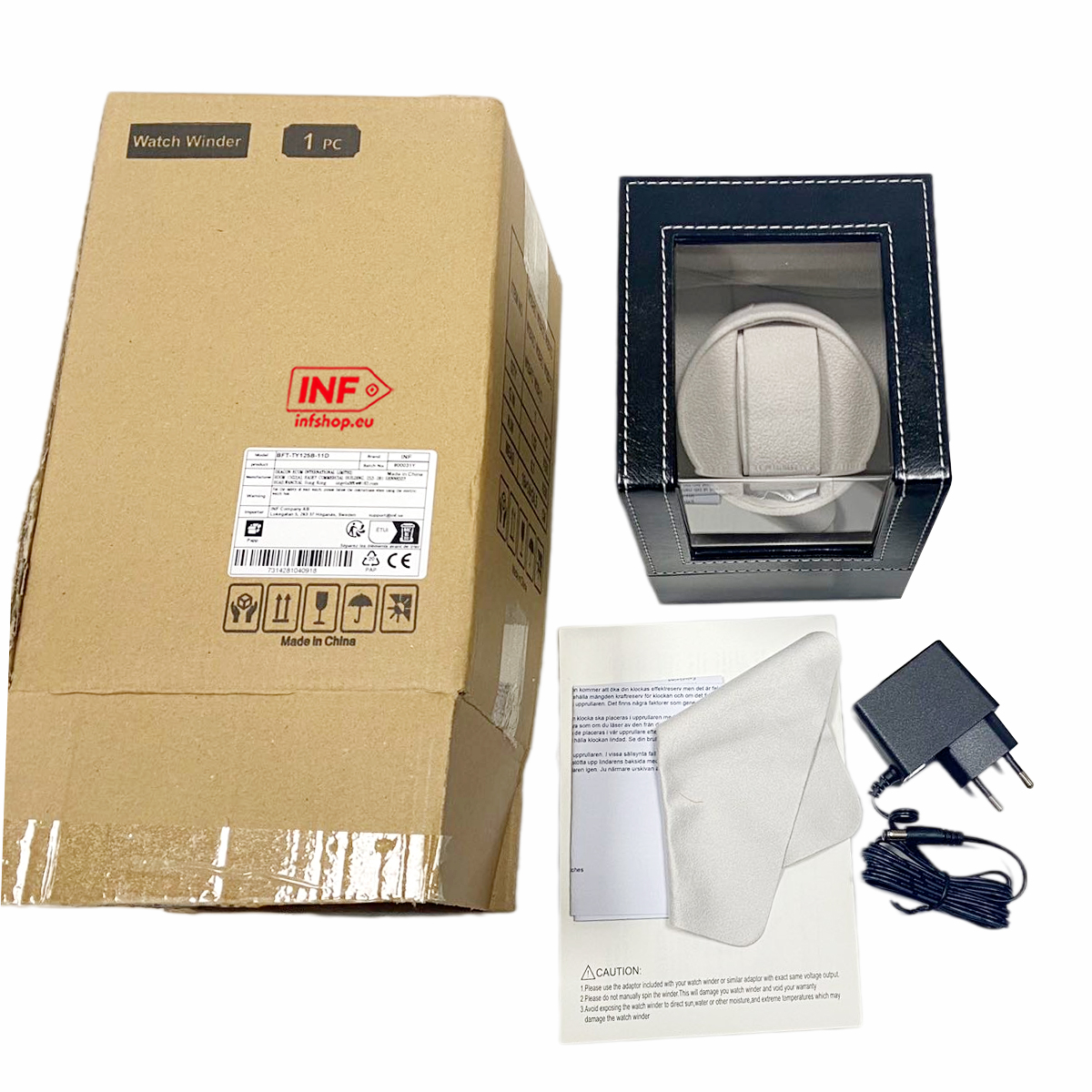Uhrenbeweger in Verpackung mit Netzteil, Reinigungstuch und Handbuch auf weißem Hintergrund.