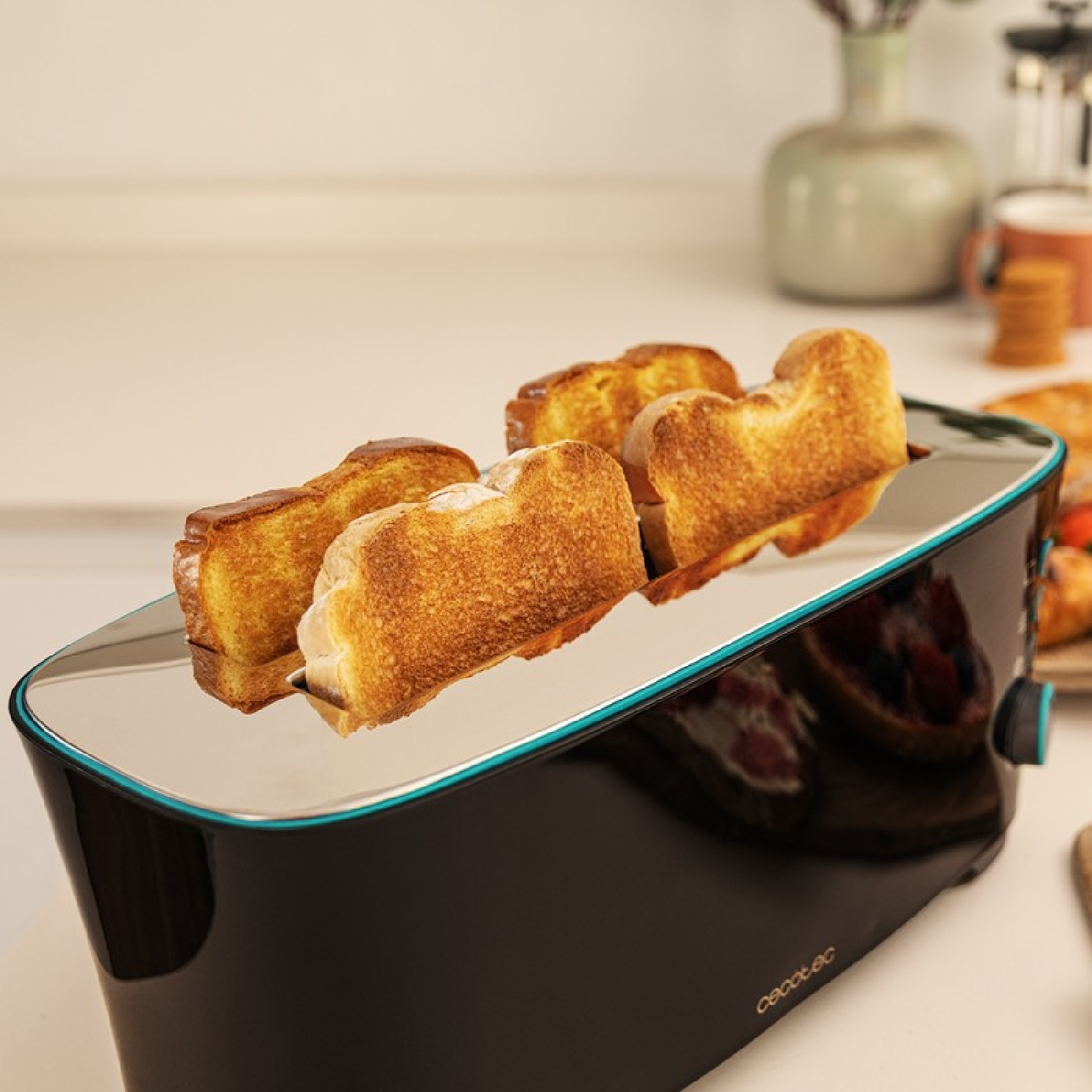 Un moderno tostapane nero con quattro fette di pane dorato in una cucina luminosa.