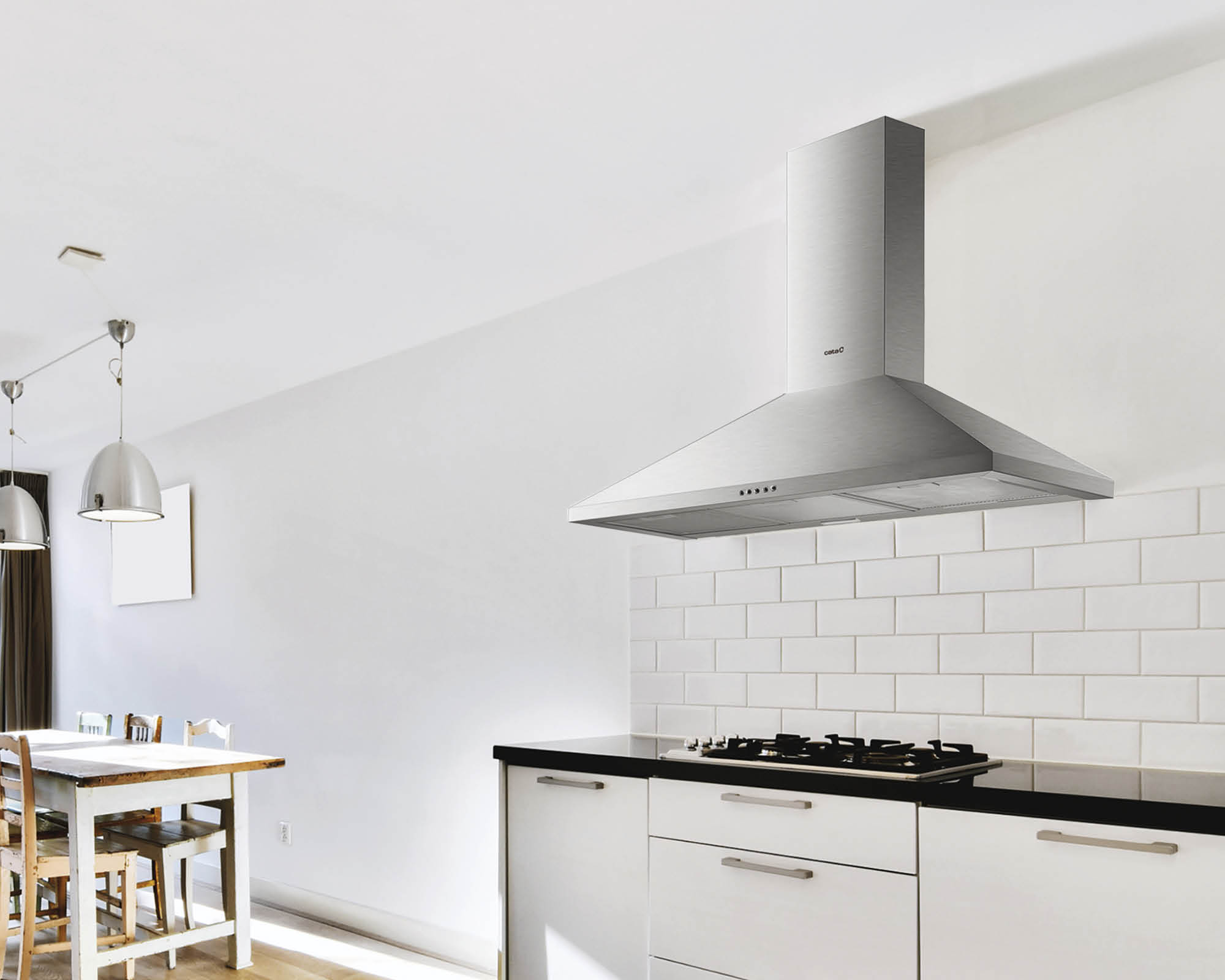 Cocina moderna con campana extractora de acero inoxidable, azulejos blancos, placa y mesa de comedor de madera.