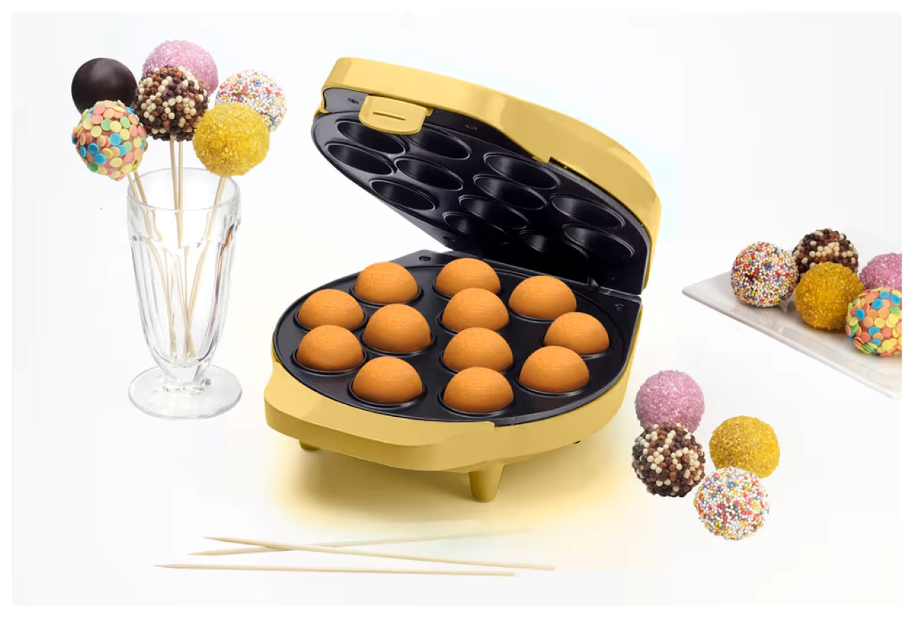 Gelber Cake-Pop-Maker mit gebackenen Kugeln, Dekorationen im Glas und auf einem Teller.