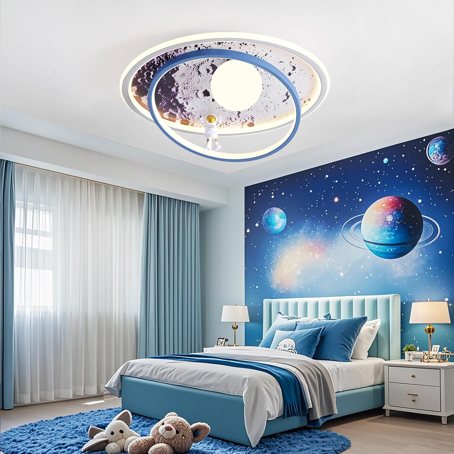 Ein Kinderzimmer mit Weltraum-Tapete, einem blauen Bett und einer planetenförmigen Deckenleuchte.