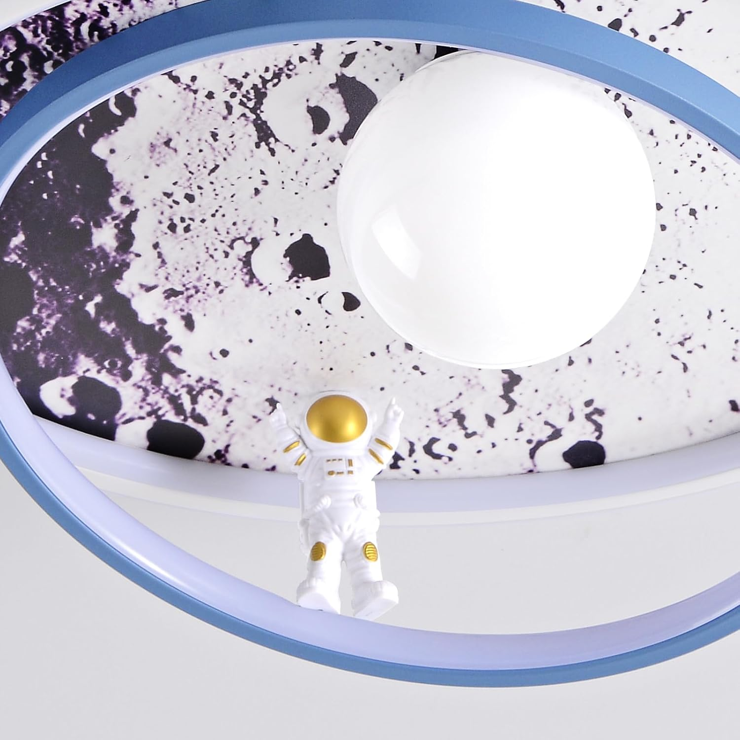 Eine blaue Deckenleuchte mit Mondmotiv und einer kleinen Astronautenfigur neben einer weißen Leuchtkugel.
