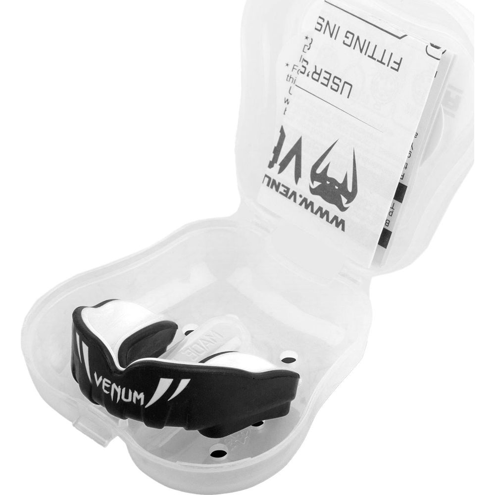 Ein schwarz-weißer Venum-Mundschutz liegt in einer offenen, transparenten Plastikbox mit Anleitung.