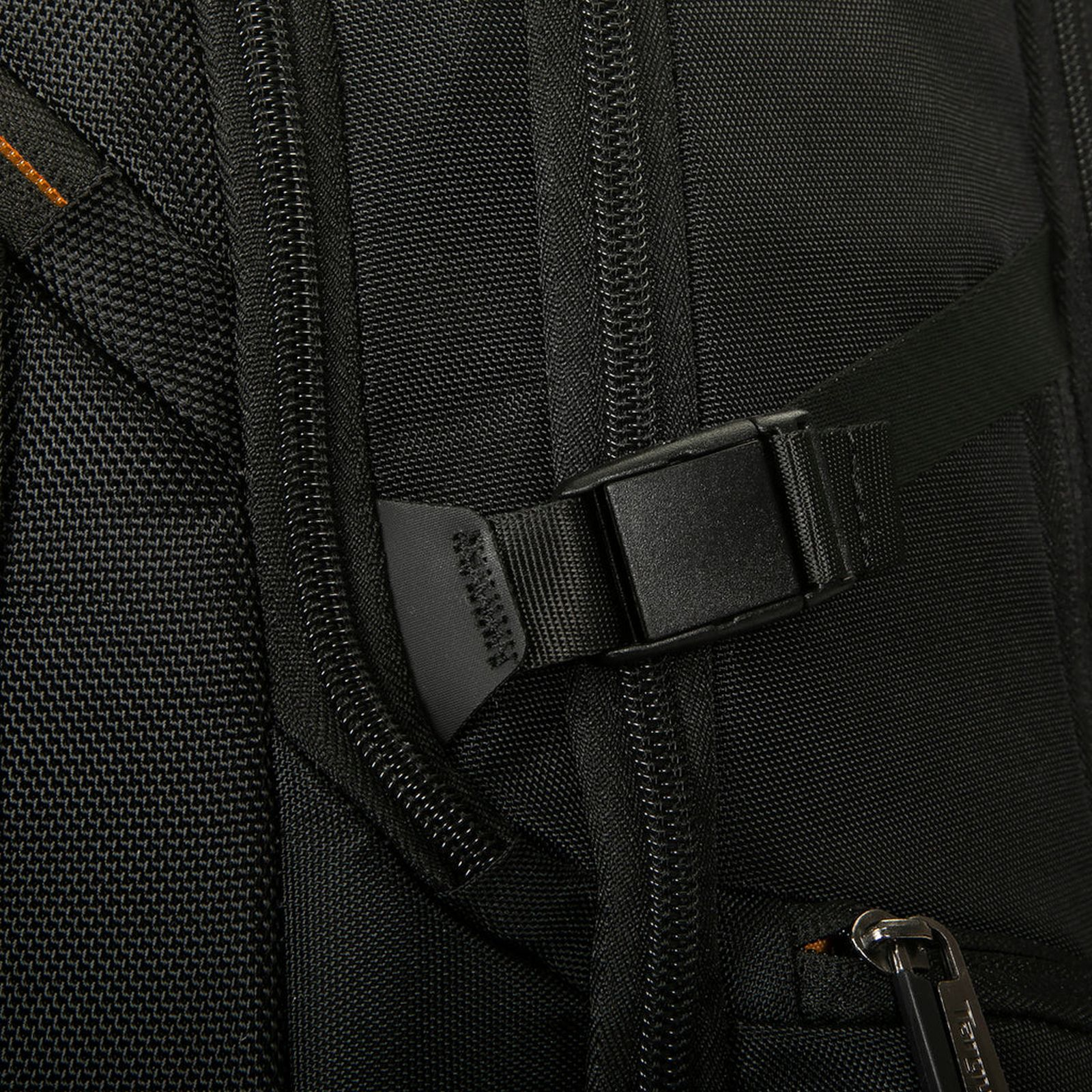 Nahaufnahme eines schwarzen Rucksacks mit Reißverschlüssen und einer Plastikschnalle.